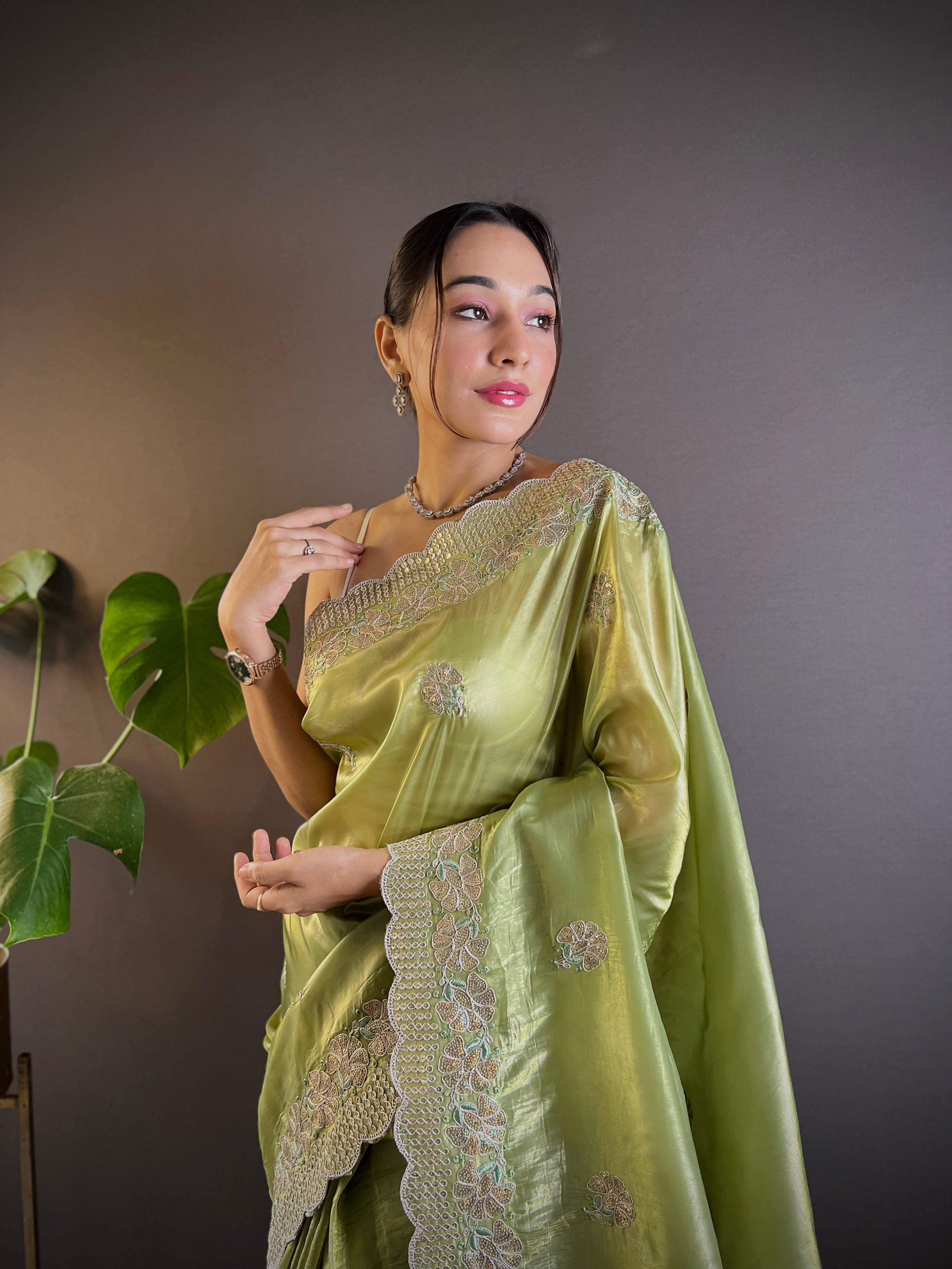 Model wearing shimmering teal blue Gold Crunchy saree with floral sequence embroidery and cutwork border