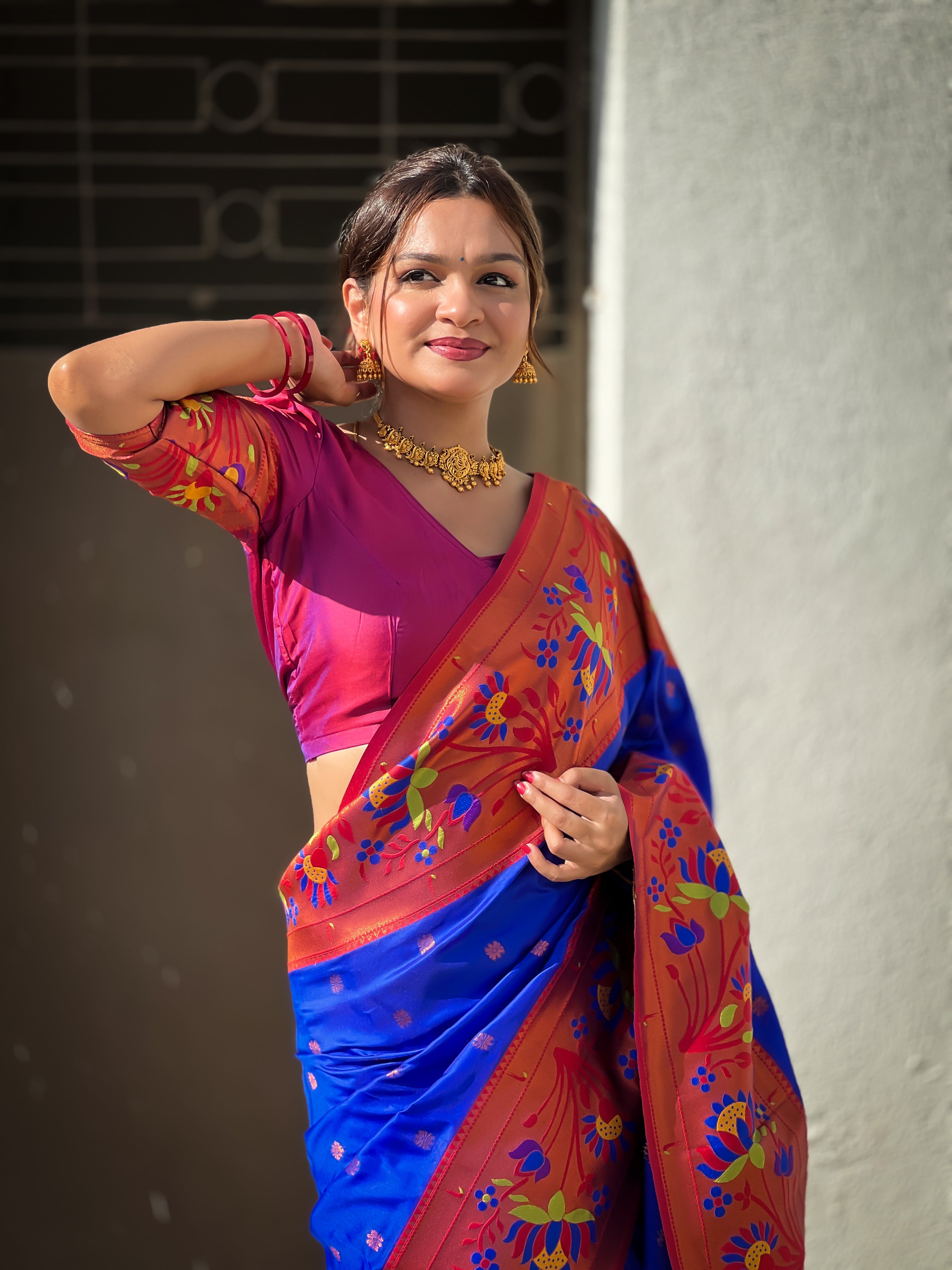 Royal blue soft Paithani silk saree with red border and meenakari floral motifs worn by a model
