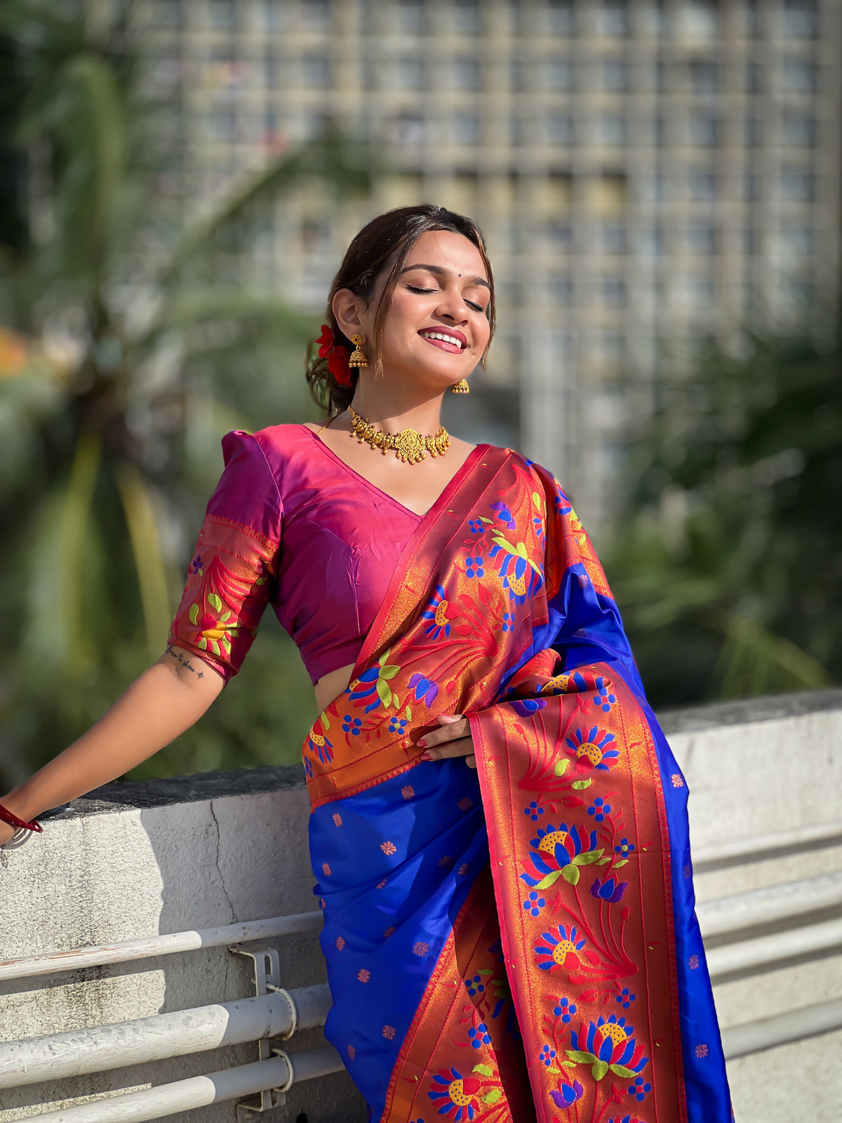 Royal blue soft Paithani silk saree with red border and meenakari floral motifs worn by a model
