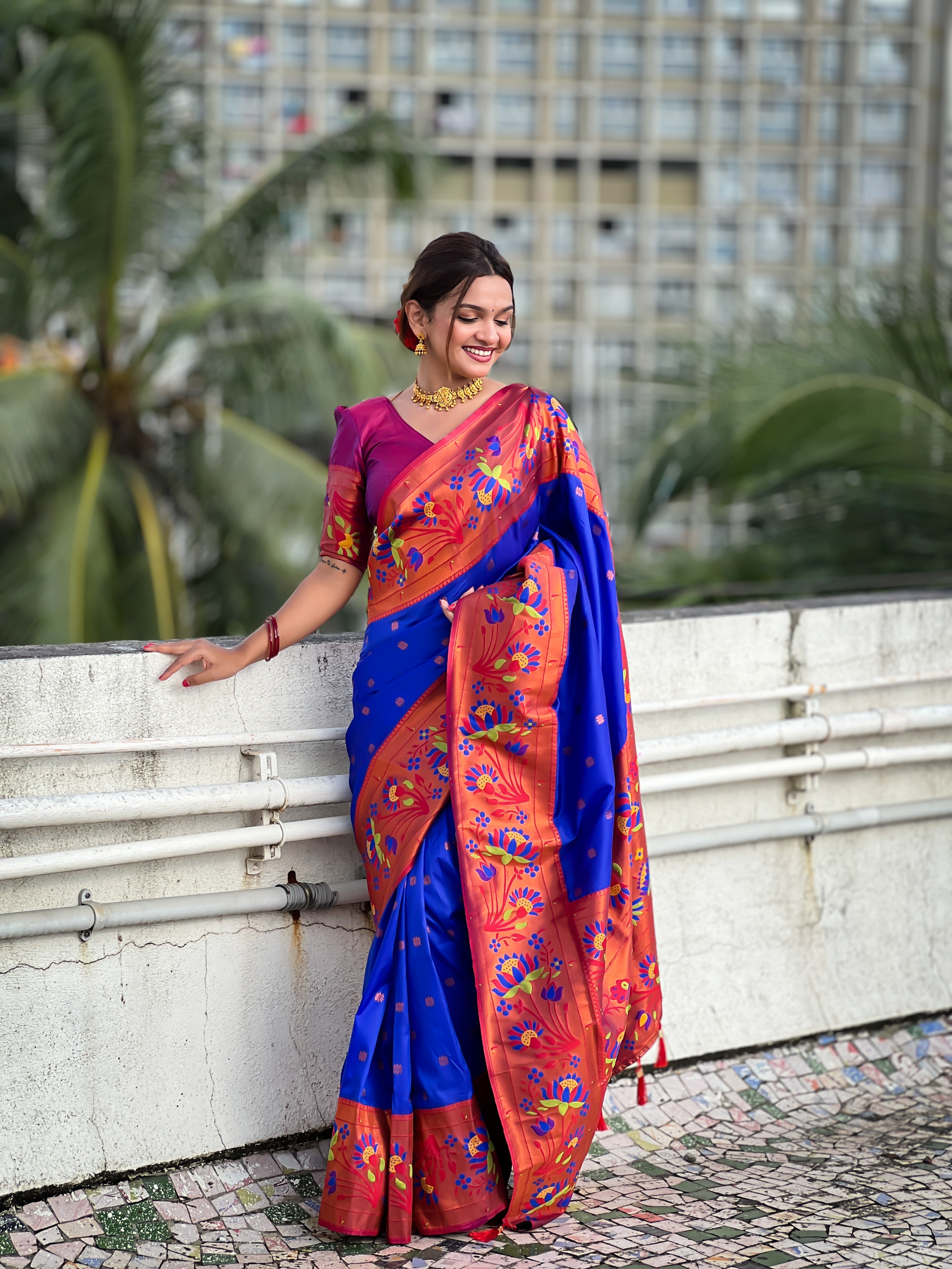 Royal blue soft Paithani silk saree with red border and meenakari floral motifs worn by a model