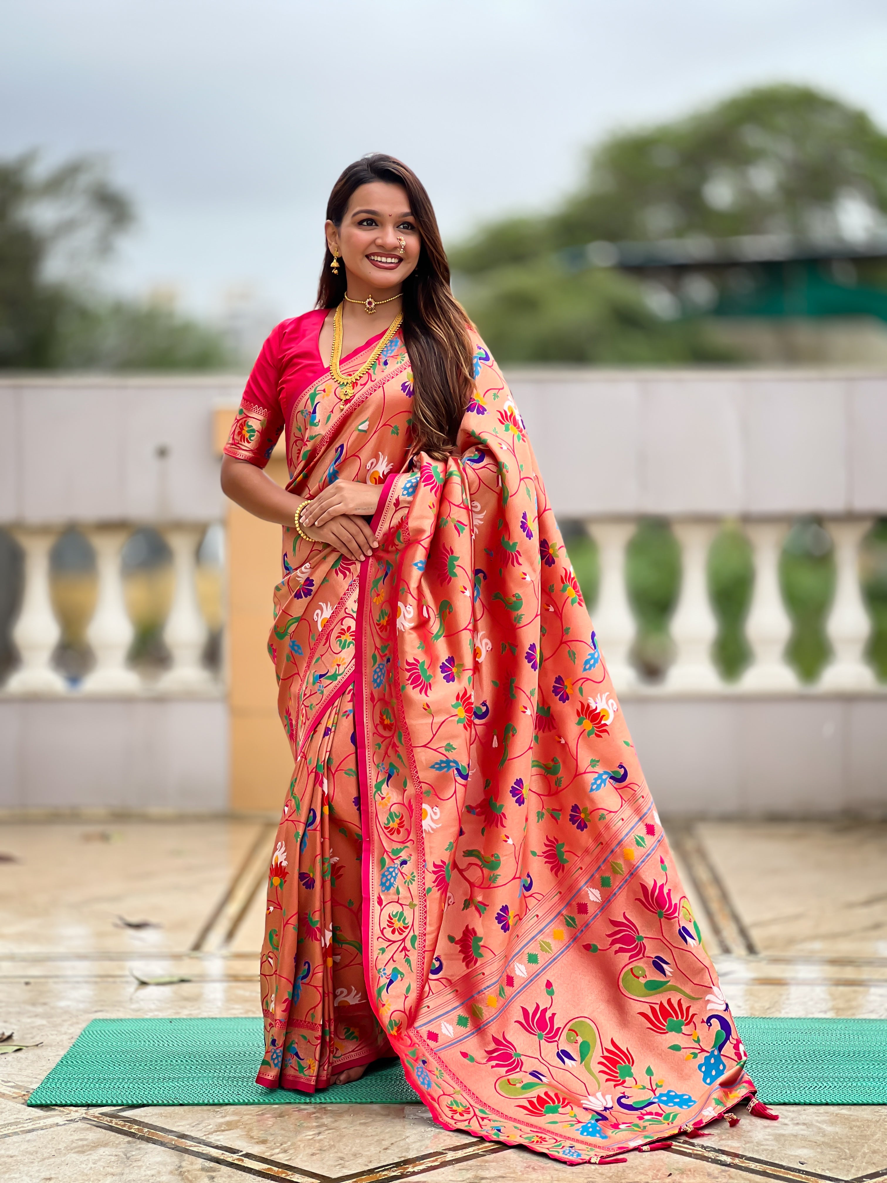 Woman wearing a peach Soft Kanjivaram Paithani Silk Saree with colorful Meenakari floral weaving and zari swan border