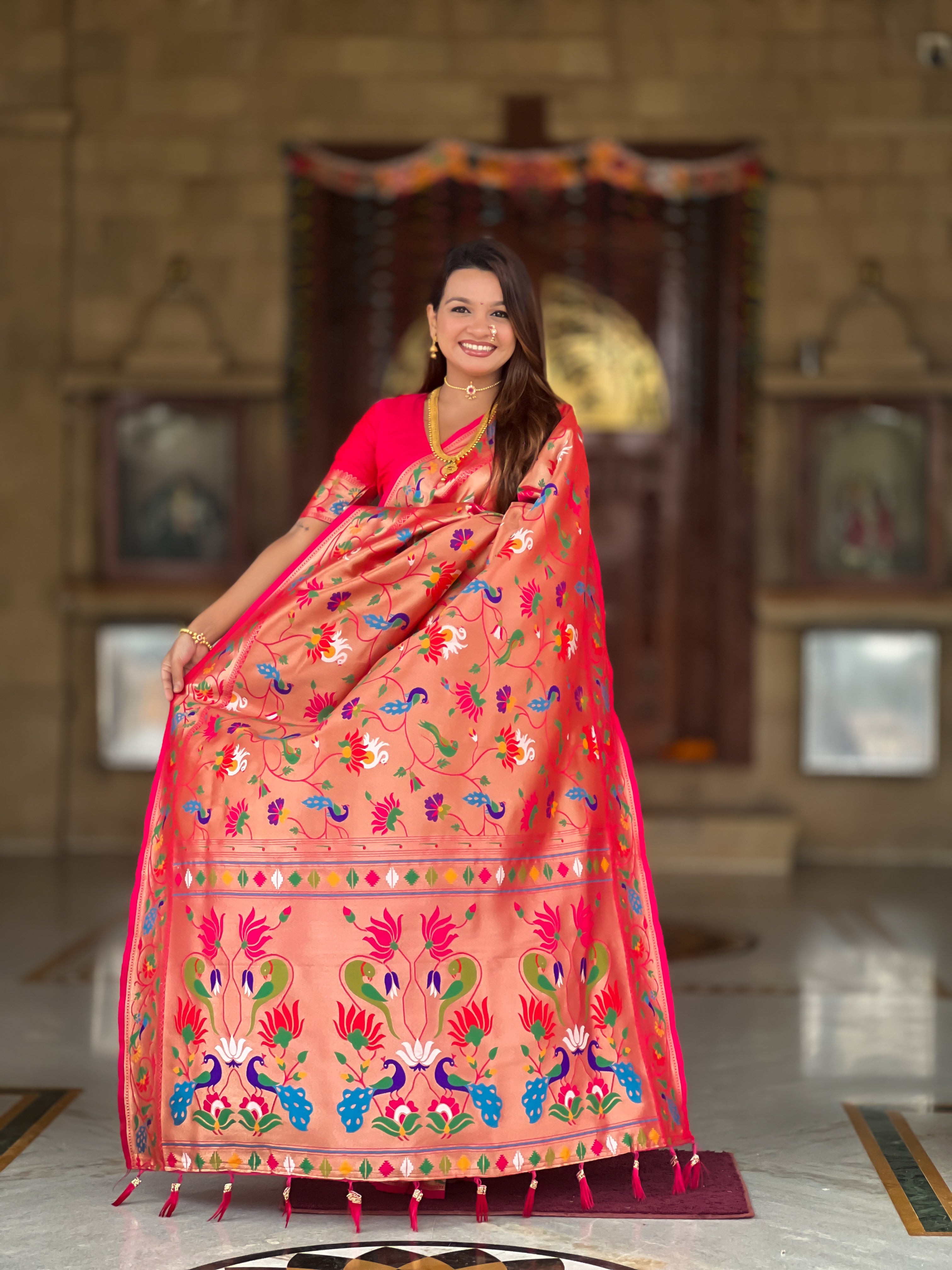 Woman wearing a peach Soft Kanjivaram Paithani Silk Saree with colorful Meenakari floral weaving and zari swan border