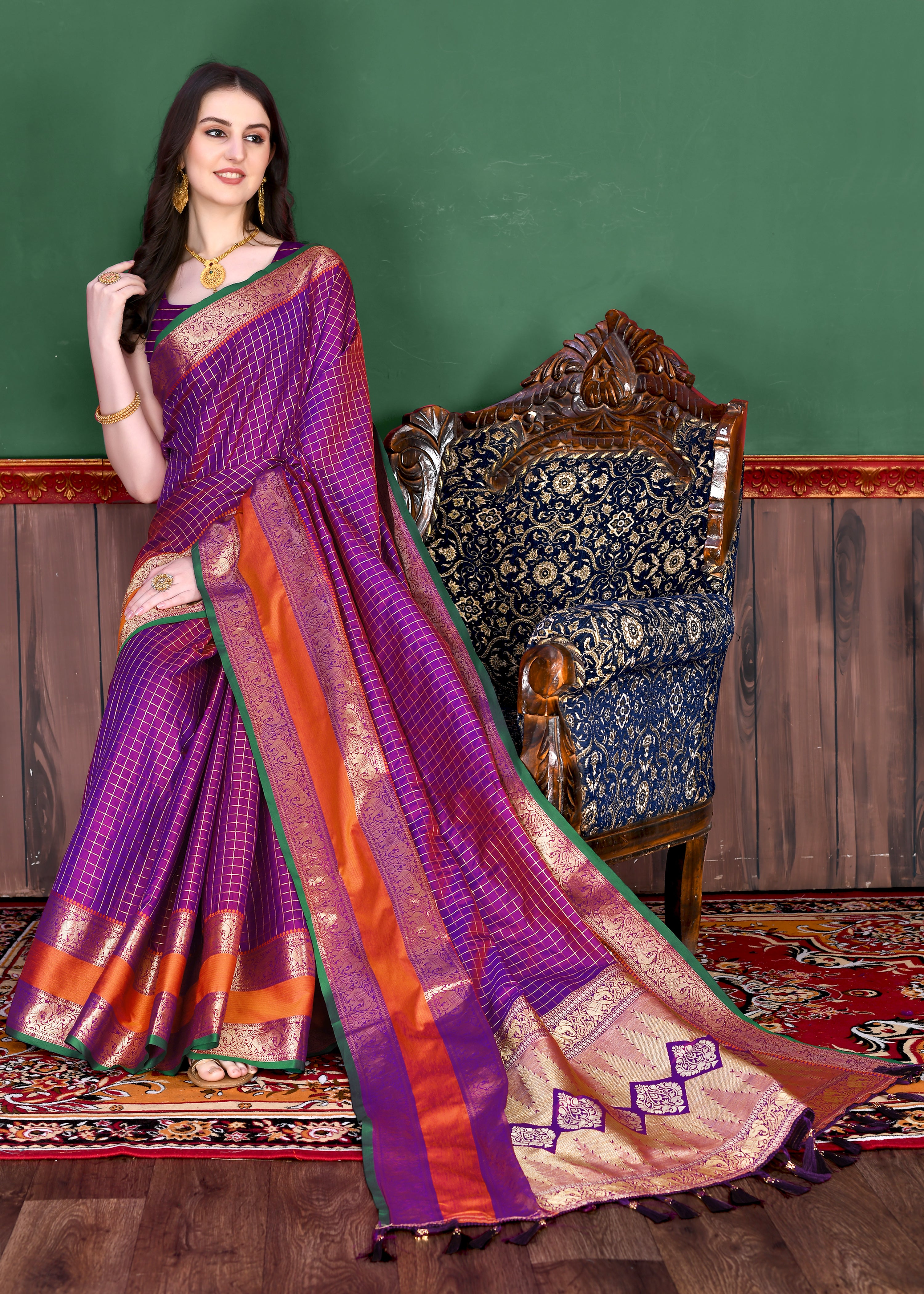 Woman wearing regal Magenta soft silk saree with gold zari checks, magenta contrast border, and rich pallu with tassels