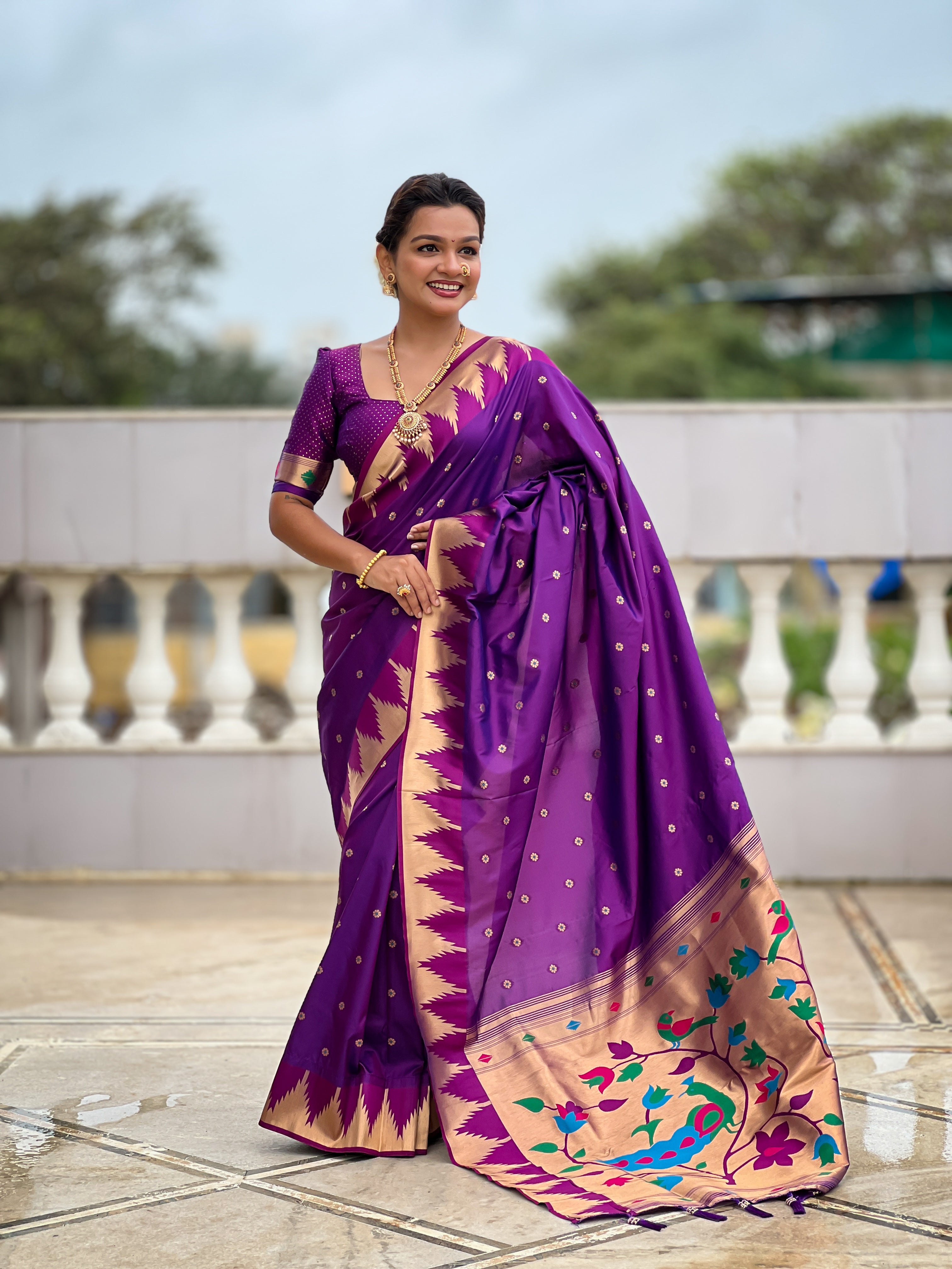 Firozi blue soft Paithani silk saree with Meenakari pallu and temple border worn by a model in a traditional setting
