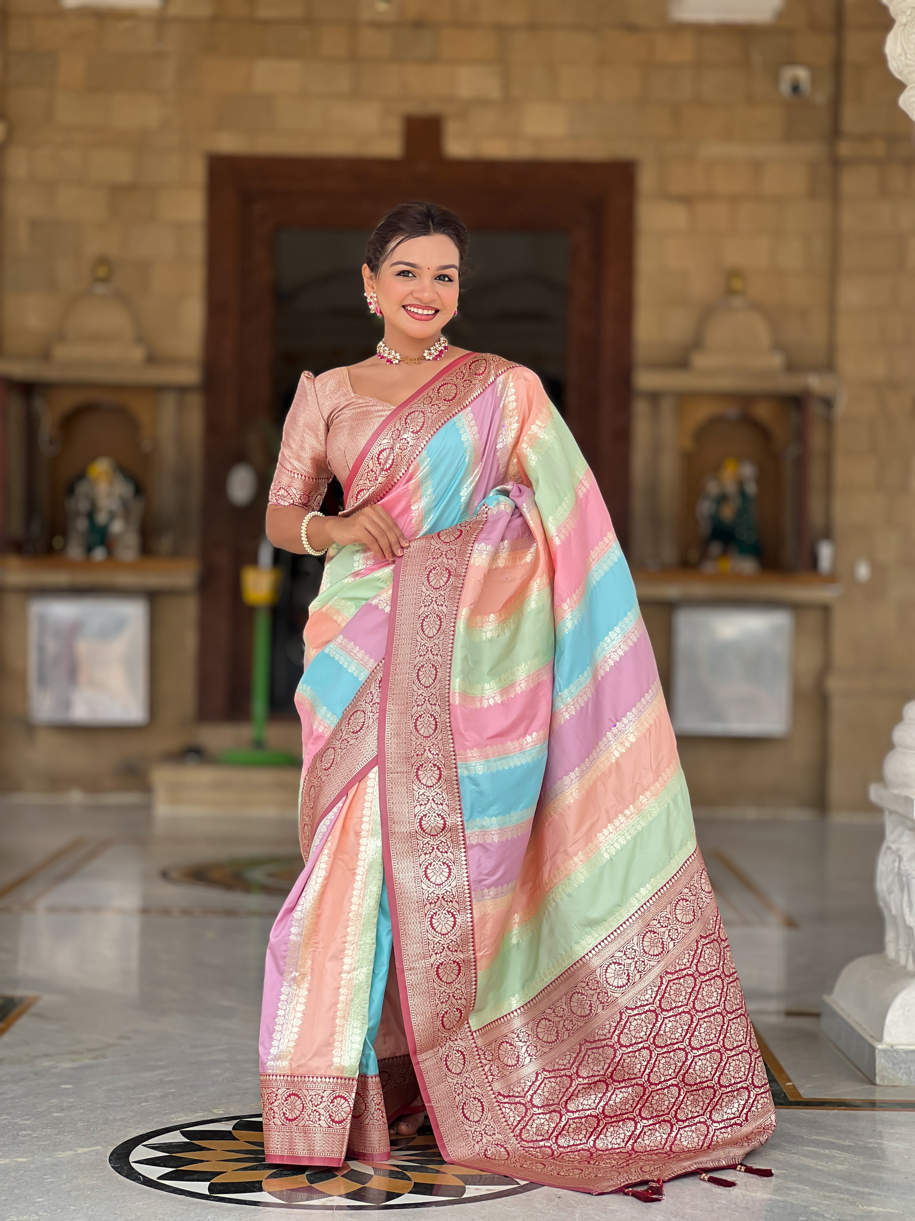 Woman wearing multi-colored pastel soft silk saree with intricate Maroon zari border and Meenakari weaving details