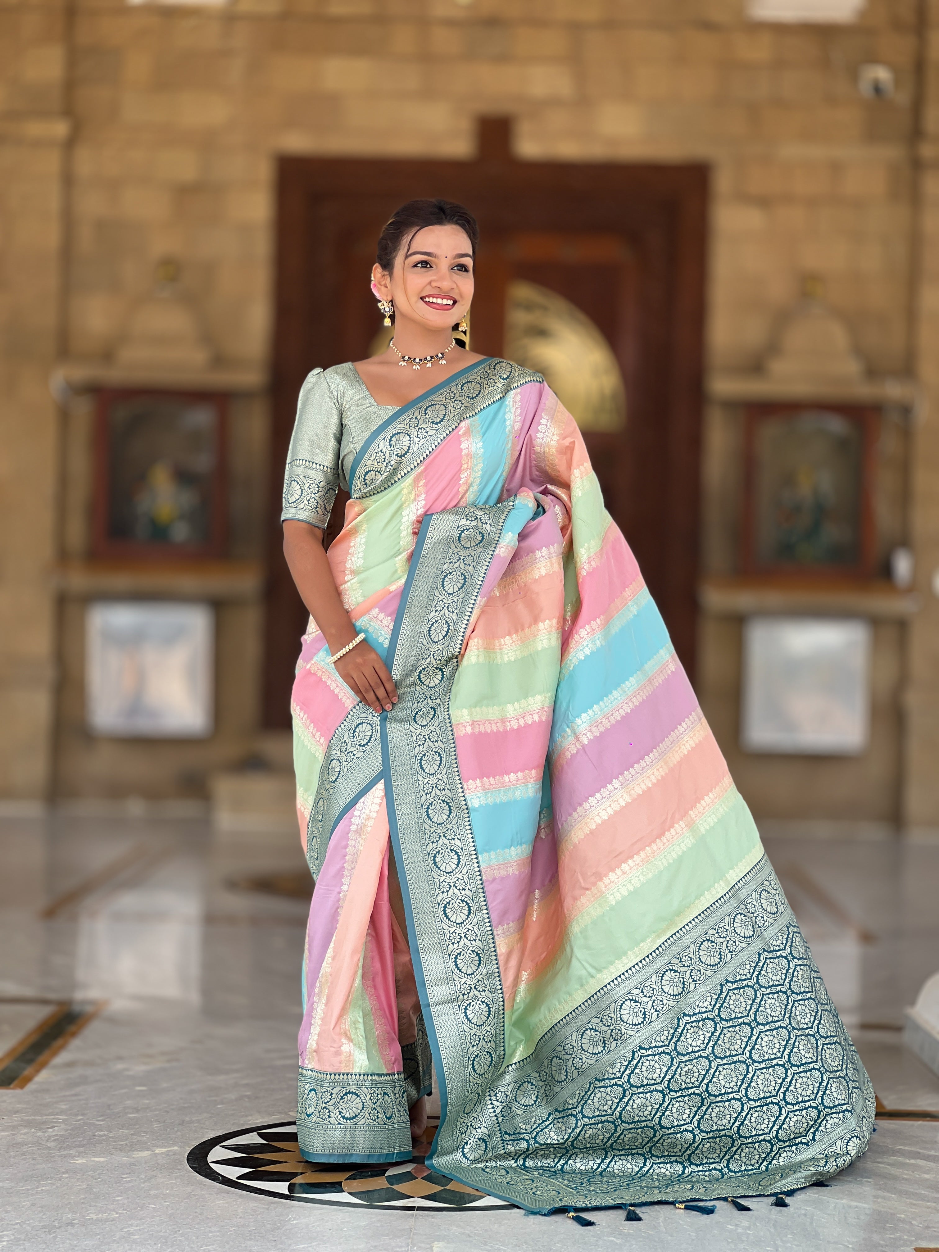 Woman wearing multi-colored pastel soft silk saree with intricate Morpich zari border and Meenakari weaving details