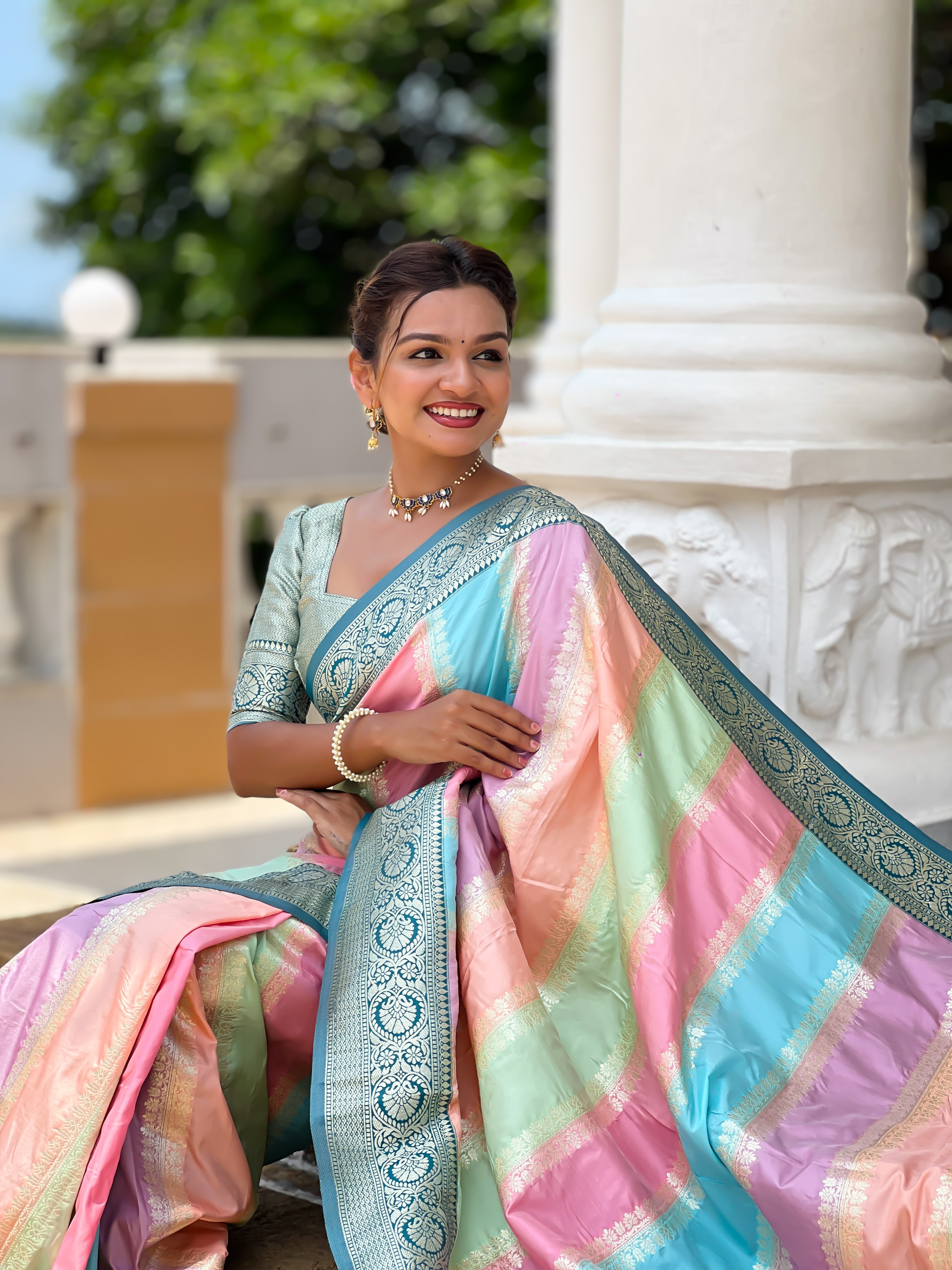 Woman wearing multi-colored pastel soft silk saree with intricate Morpich zari border and Meenakari weaving details