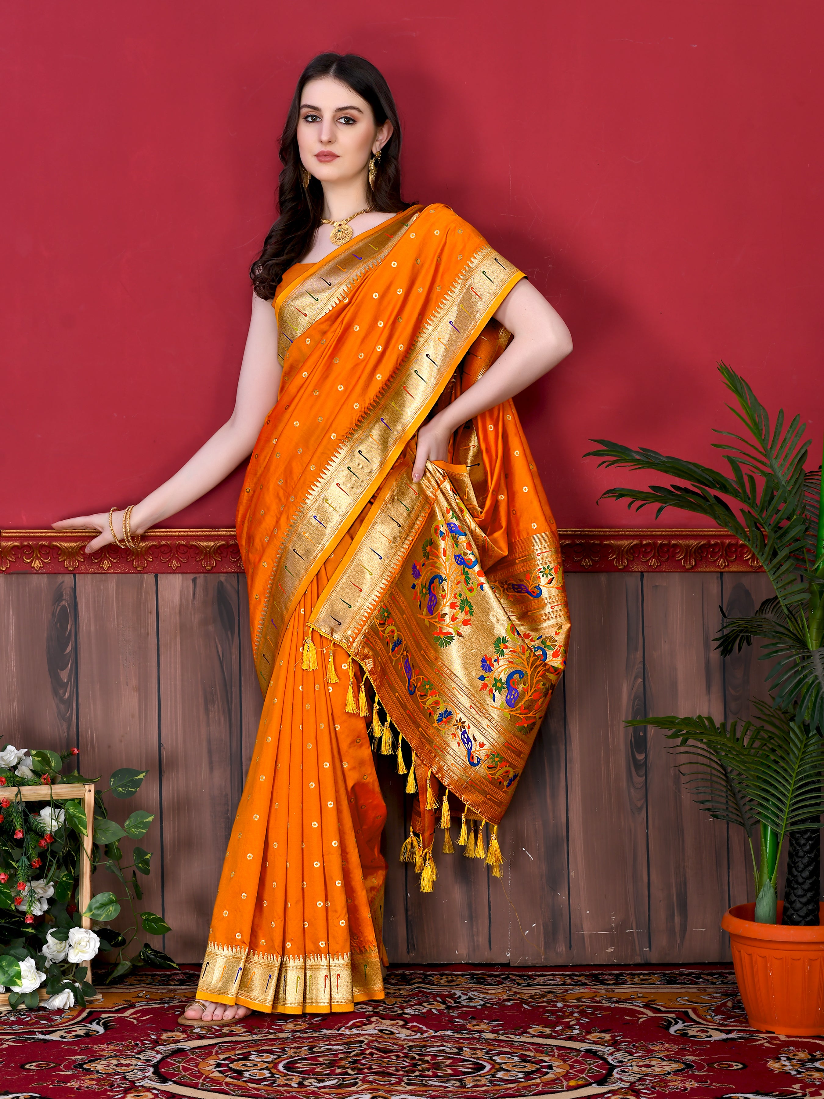 Model wearing Orange Soft Paithani Silk Saree with gold zari Meenakari border and rich pallu for wedding