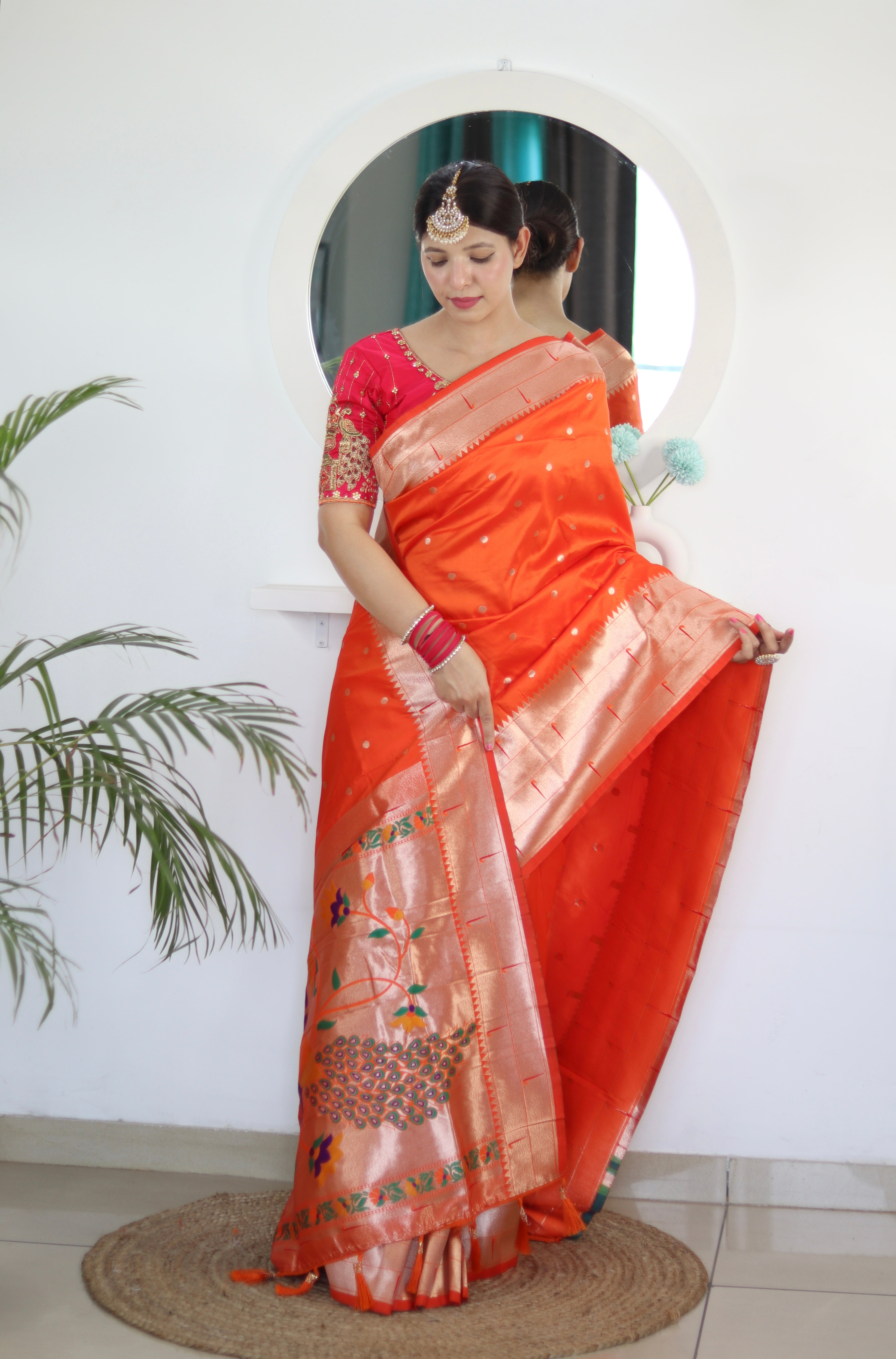 Model wearing Orange Soft Kanjivaram Paithani Silk Saree with Meenakari Zari weaving and rich swan border