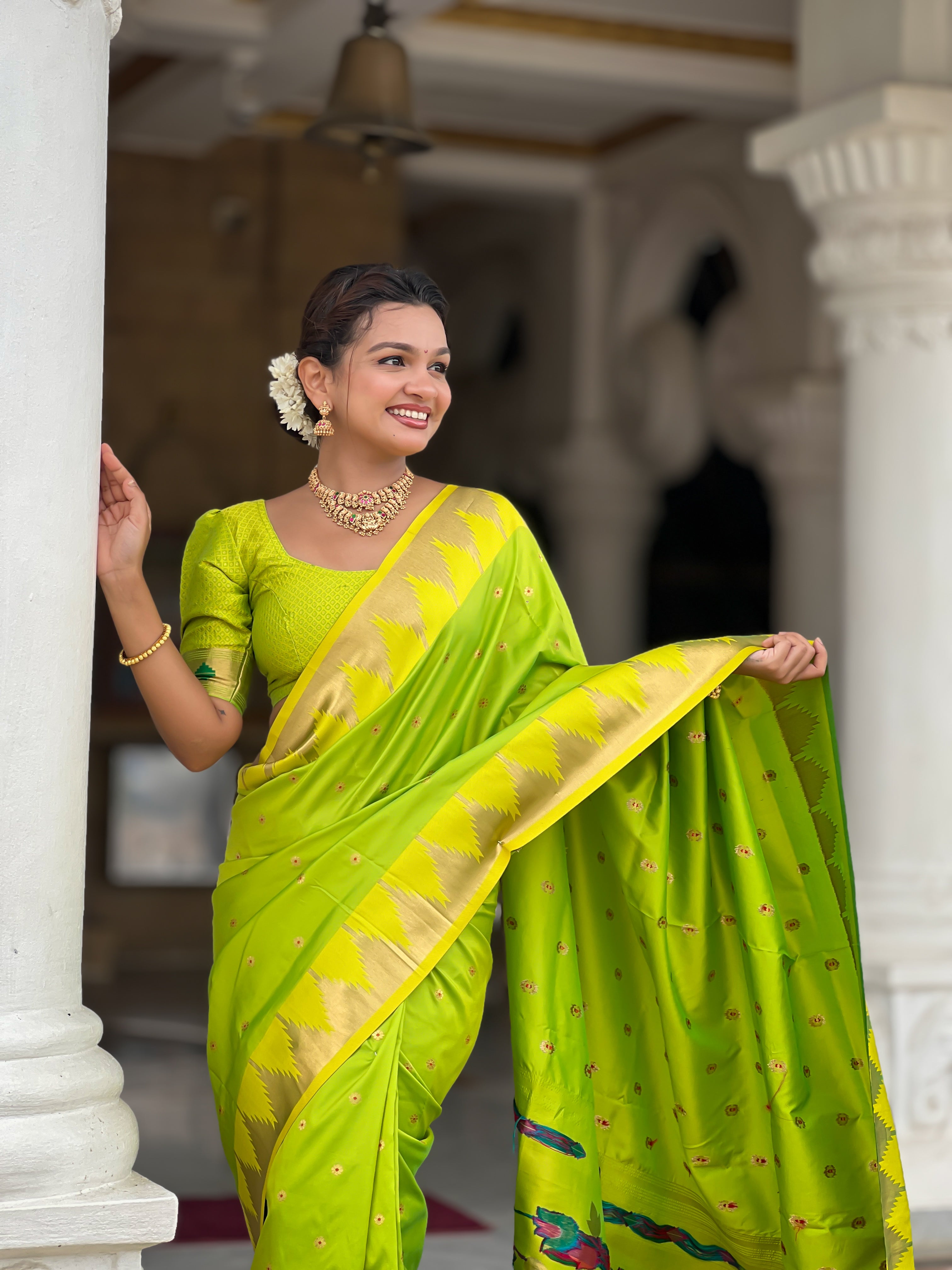 Firozi blue soft Paithani silk saree with Meenakari pallu and temple border worn by a model in a traditional setting