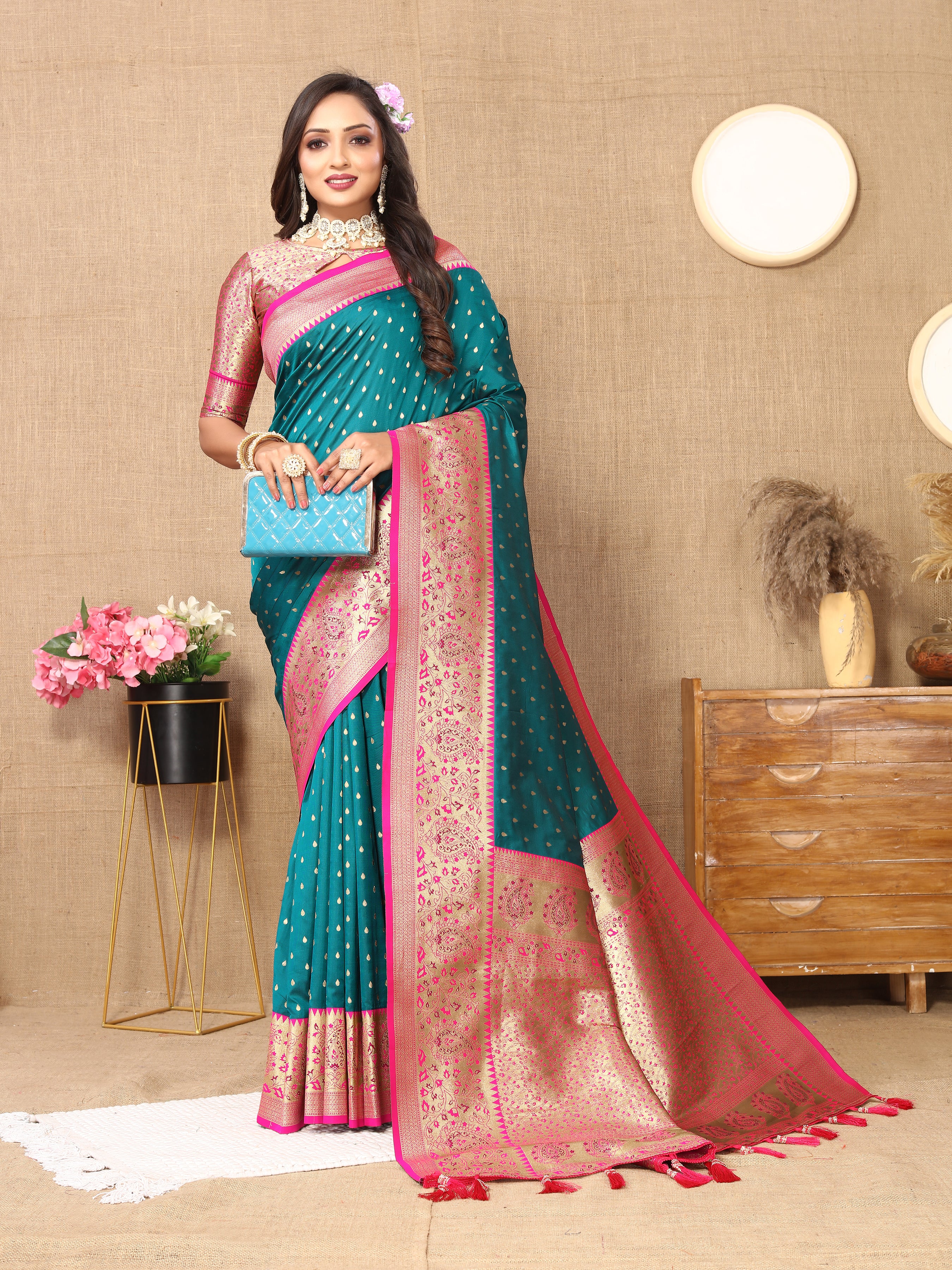 Woman wearing Rama soft silk saree with pink contrast border, gold zari motifs, and rich pallu design