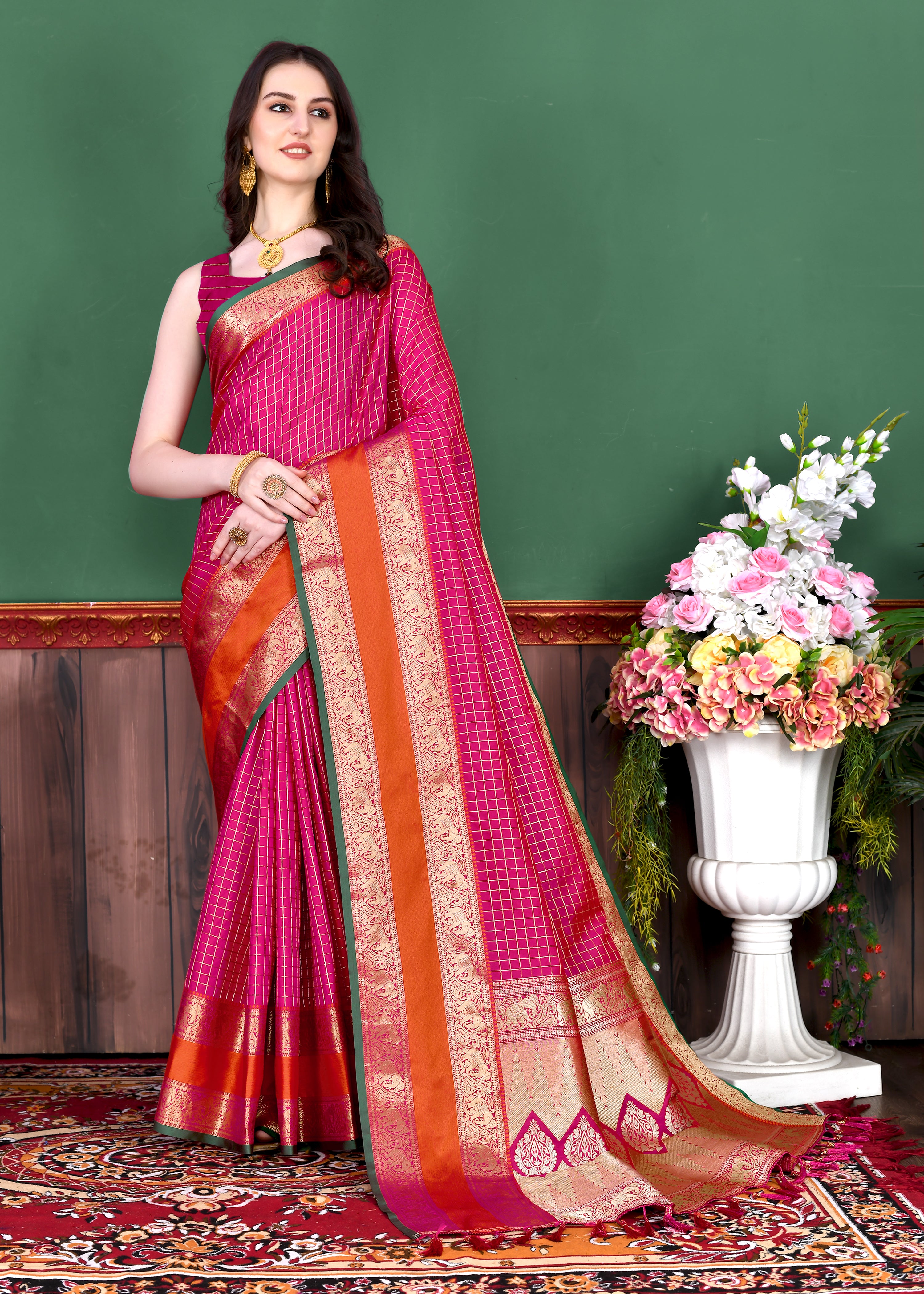 Woman wearing regal Pink soft silk saree with gold zari checks, contrast border, and rich pallu with tassels