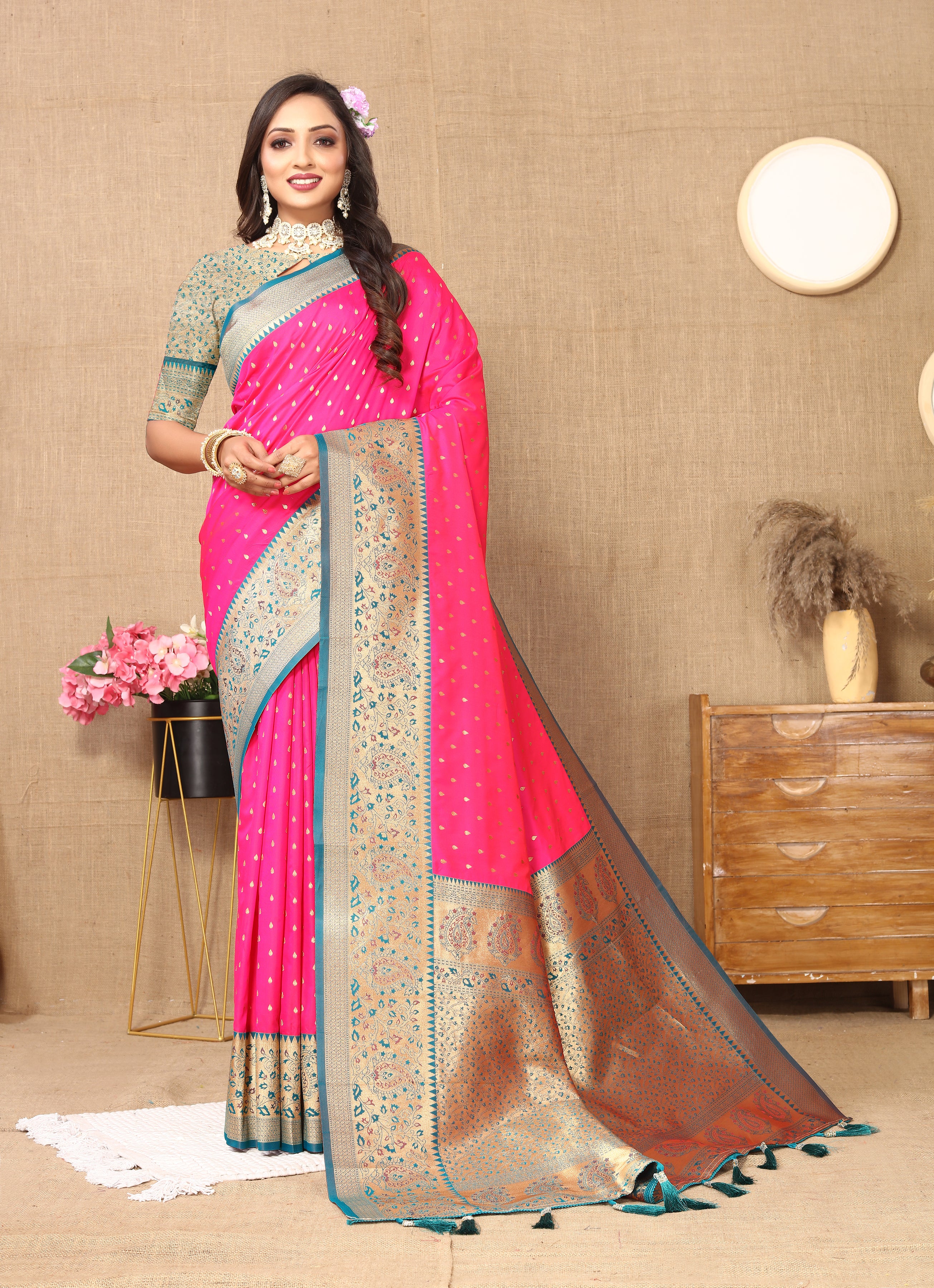 Woman wearing Rani  soft silk saree with pink contrast border, gold zari motifs, and rich pallu design