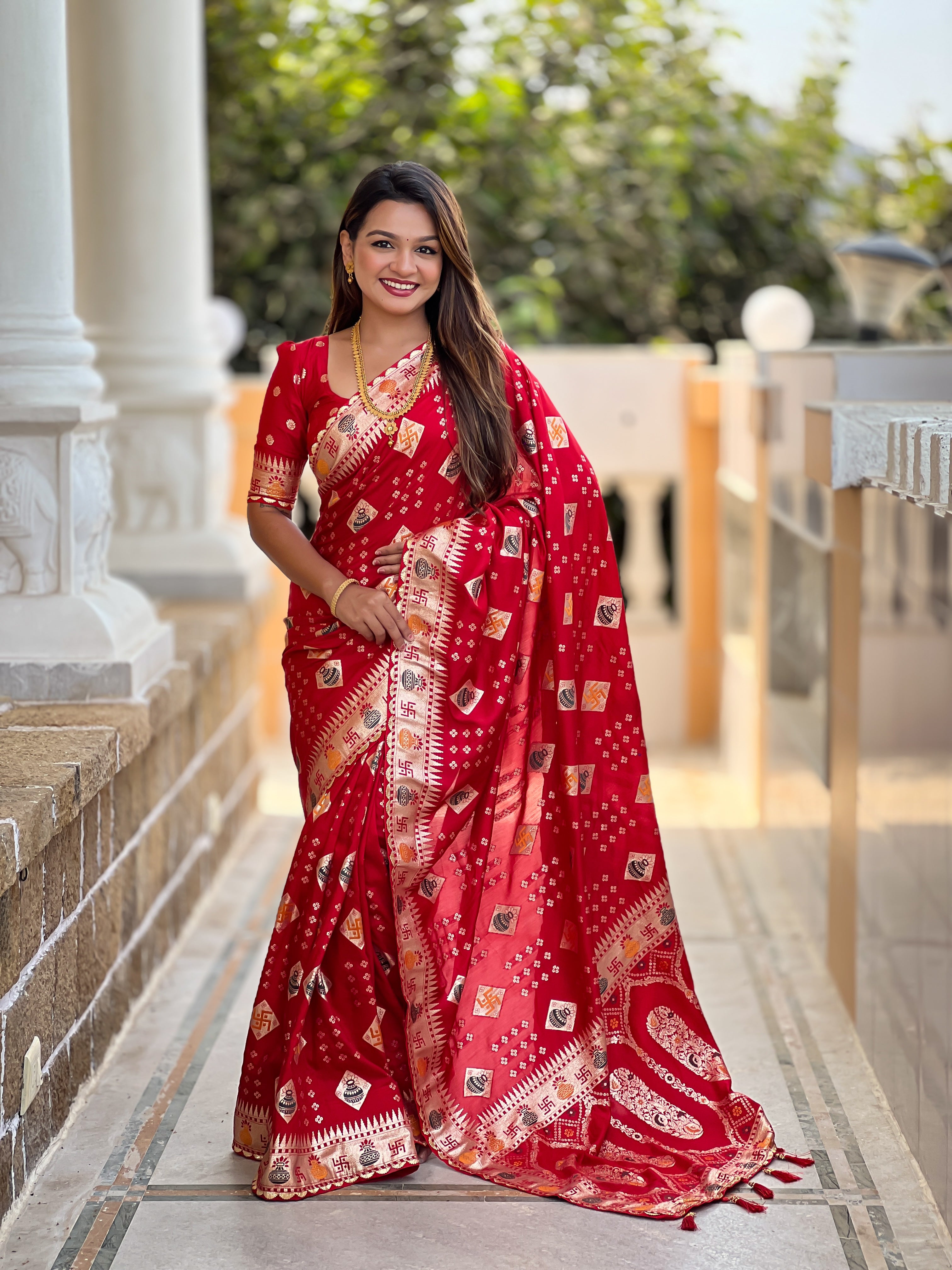 Woman wearing a Red soft dola silk saree with gold zari and meenakari weaving, featuring a heavy pallu and tassels, ideal for indian weddings
