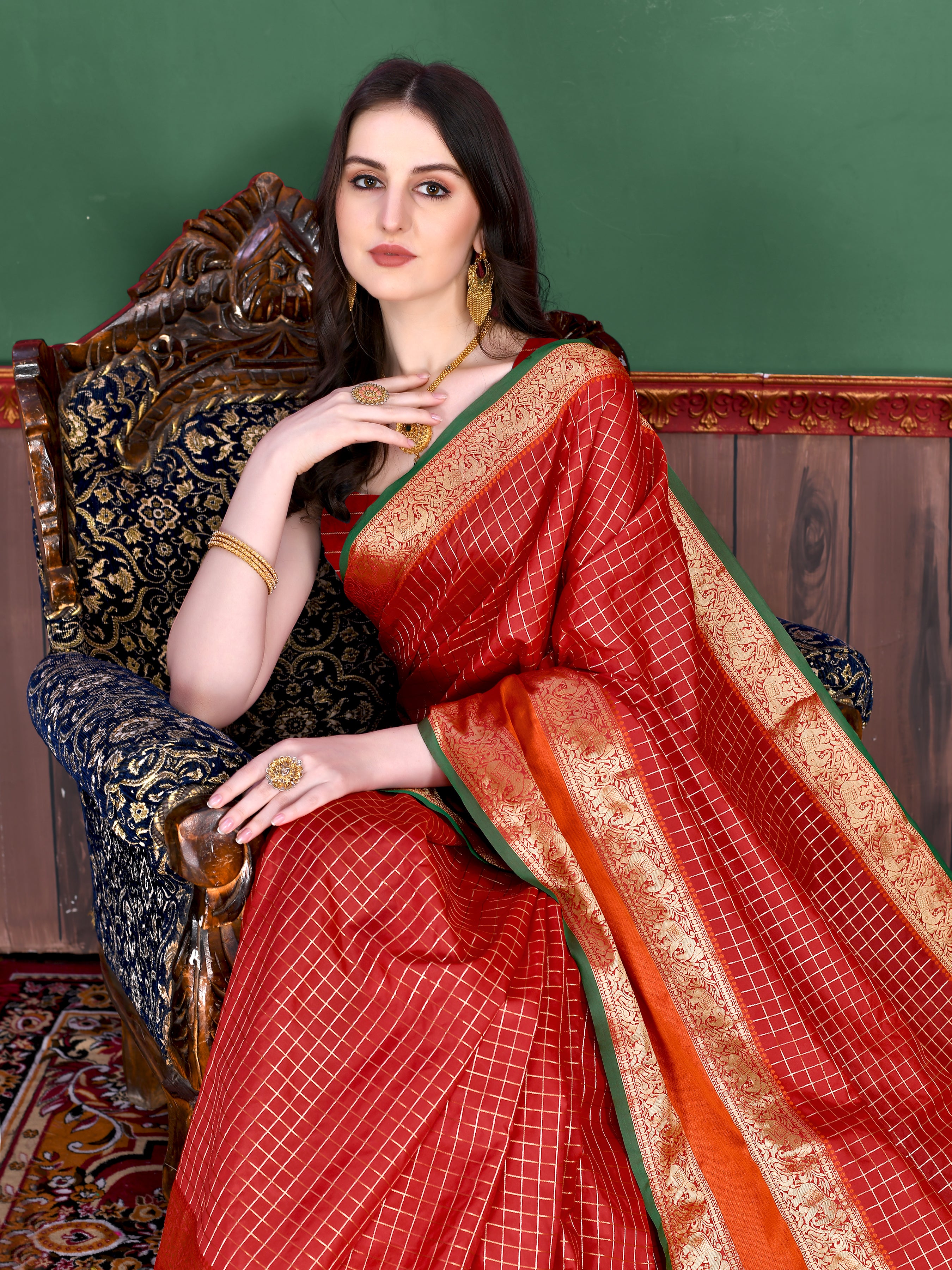 Woman wearing regal Red soft silk saree with gold zari checks, contrast border, and rich pallu with tassels