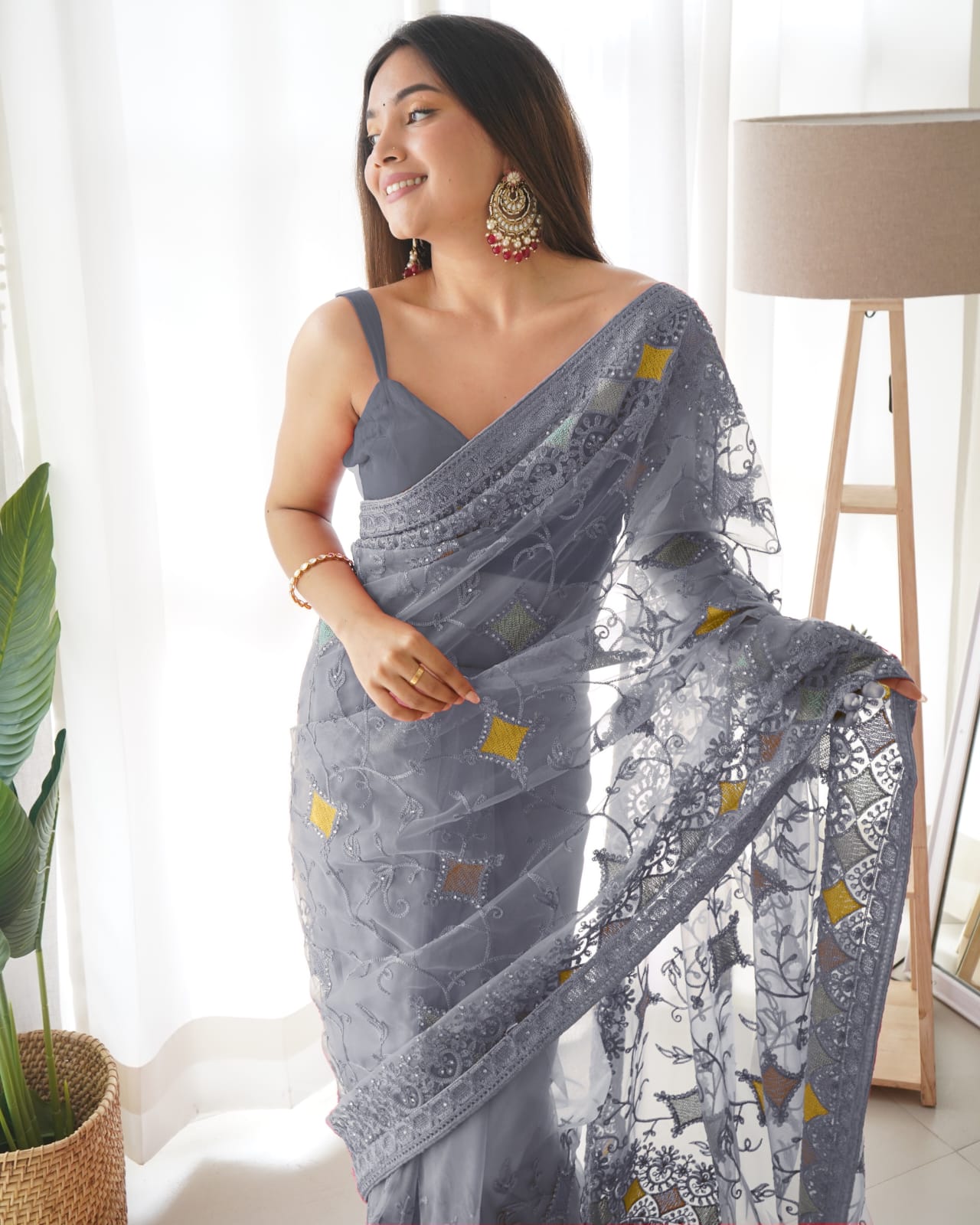 Woman wearing Grey heavy butterfly net saree with multi-color aari embroidery and stone work details