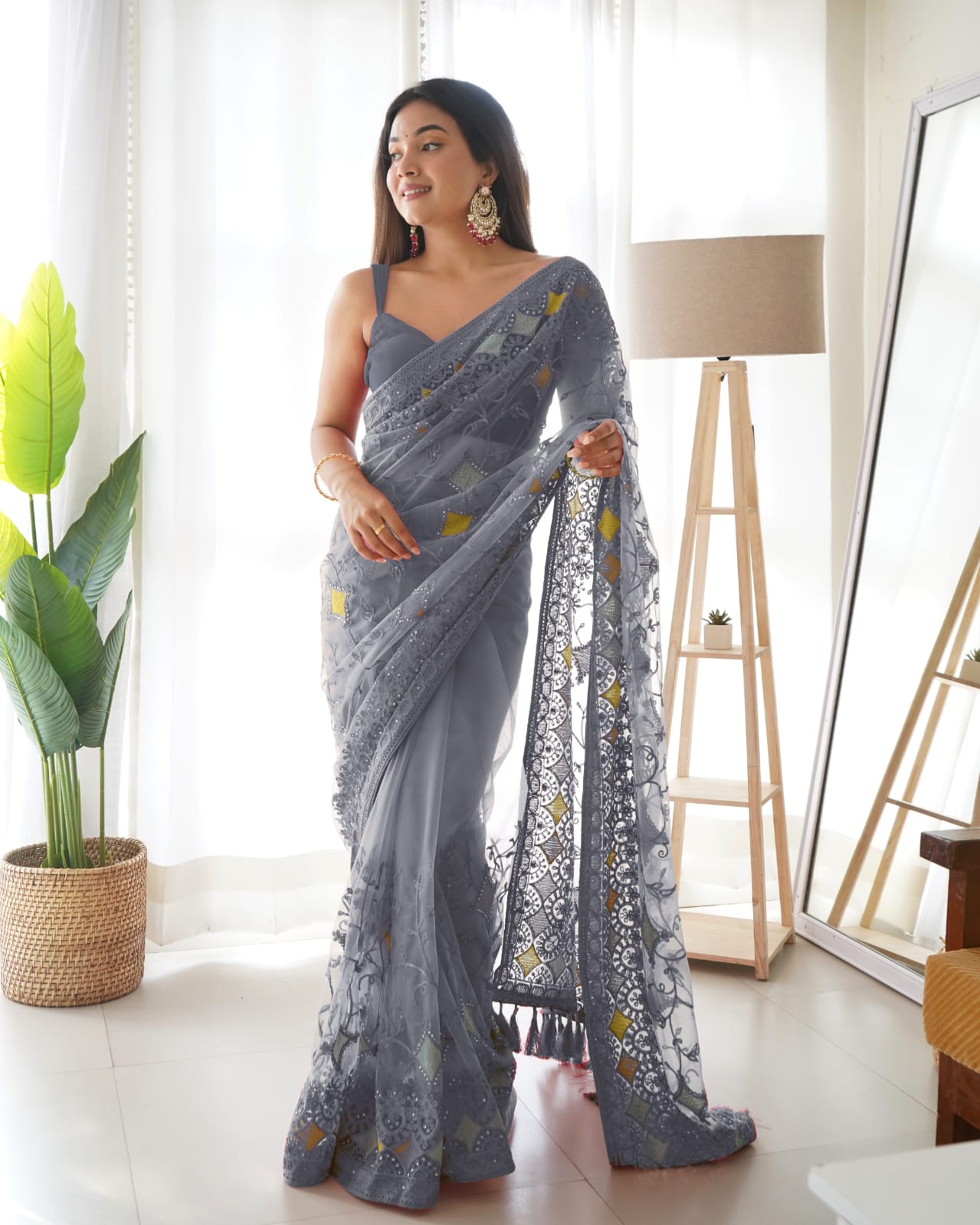 Woman wearing Grey heavy butterfly net saree with multi-color aari embroidery and stone work details
