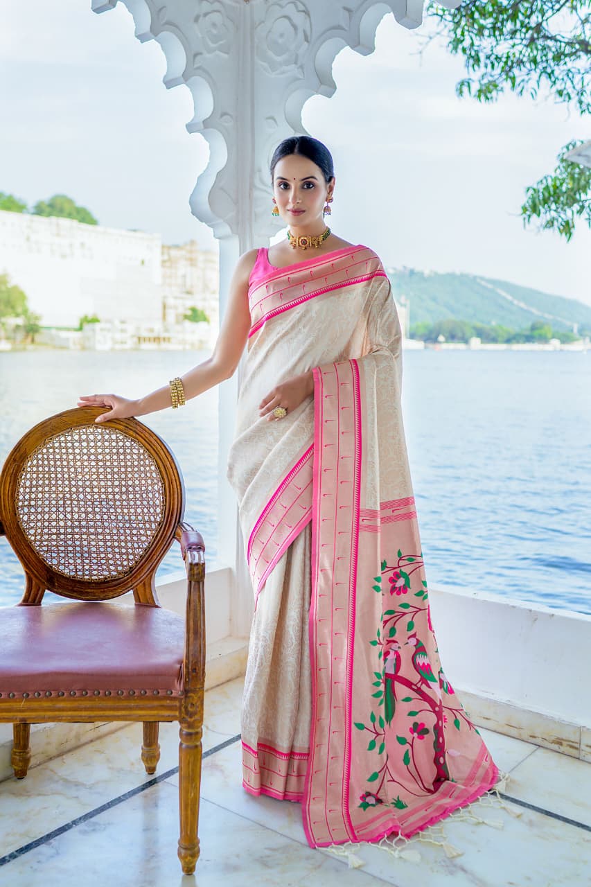 Model wearing grey Kanchi-Paithani fusion silk saree with blue border and colorful bird motif pallu standing in heritage courtyard