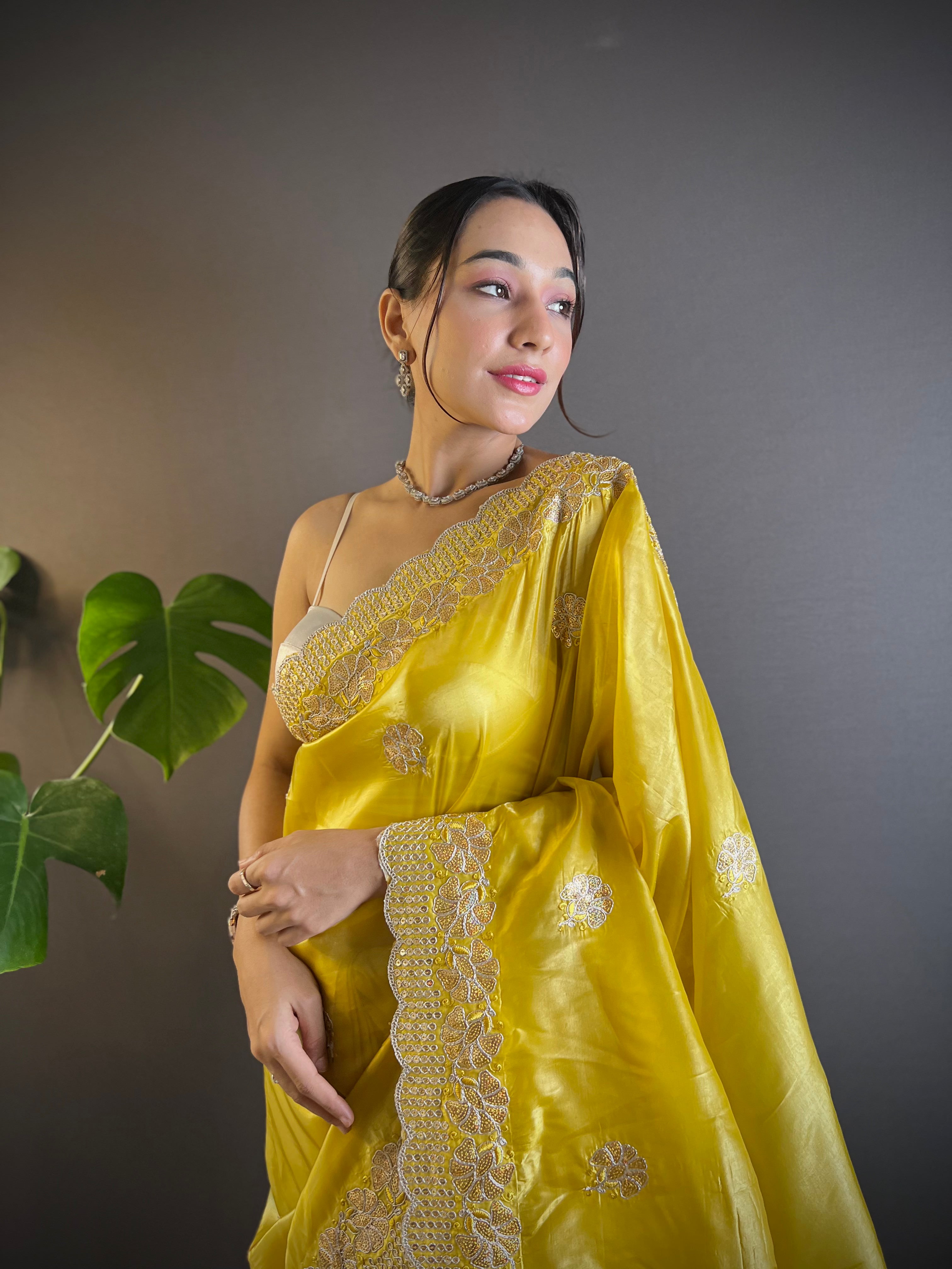 Model wearing shimmering teal blue Gold Crunchy saree with floral sequence embroidery and cutwork border