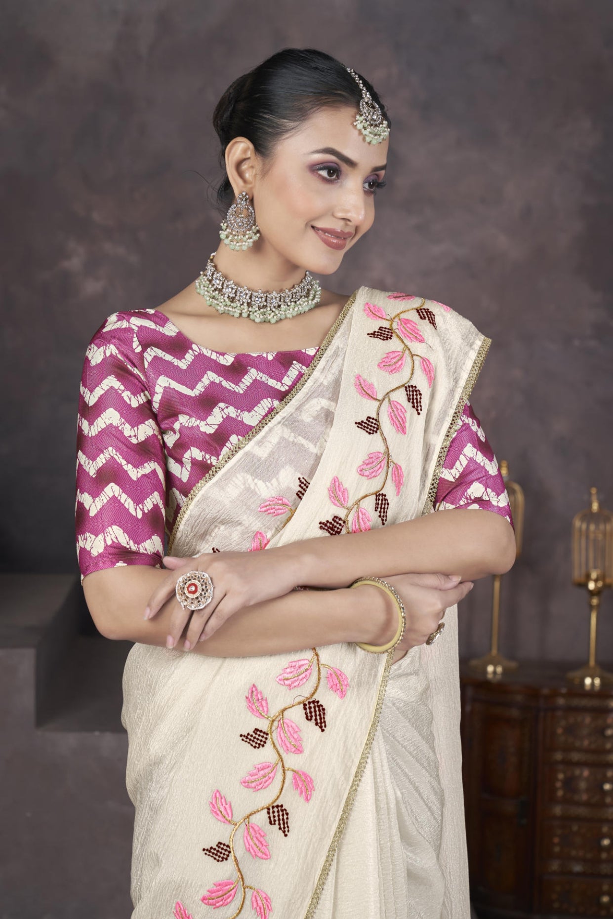 Model wearing Cream soft crush georgette saree with blue leaf thread embroidery and chevron batik blouse