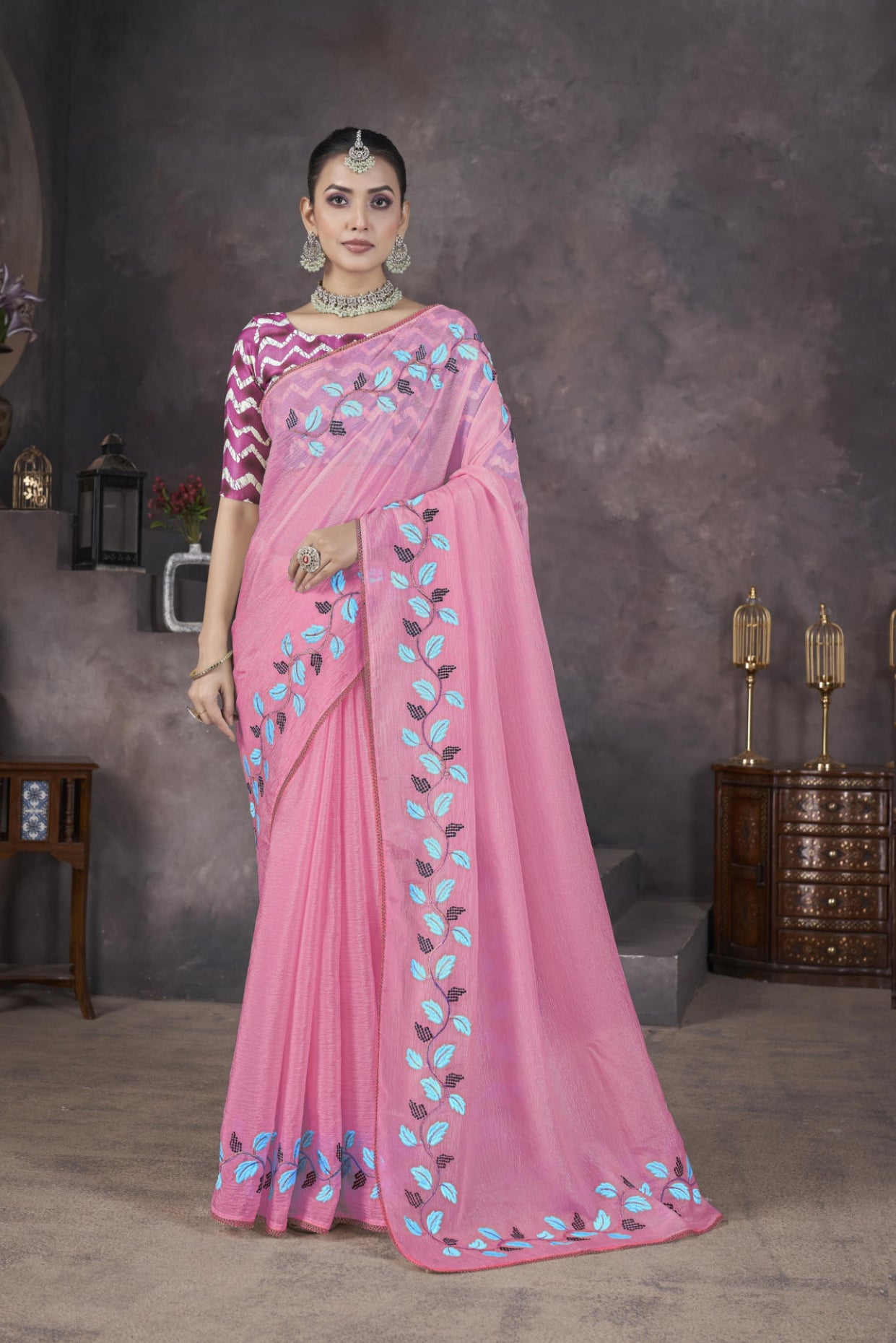 Model wearing Pink soft crush georgette saree with blue leaf thread embroidery and chevron batik blouse