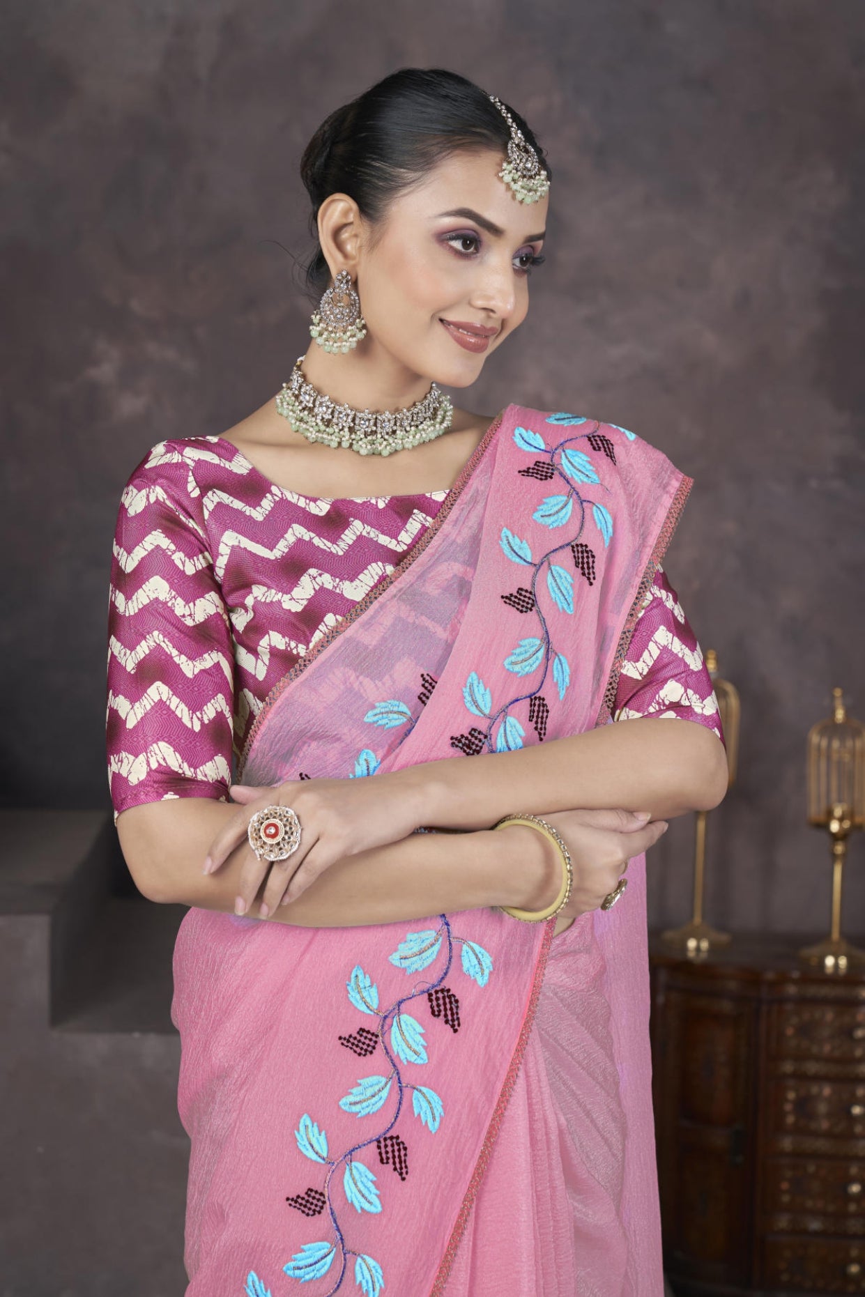 Model wearing Pink soft crush georgette saree with blue leaf thread embroidery and chevron batik blouse