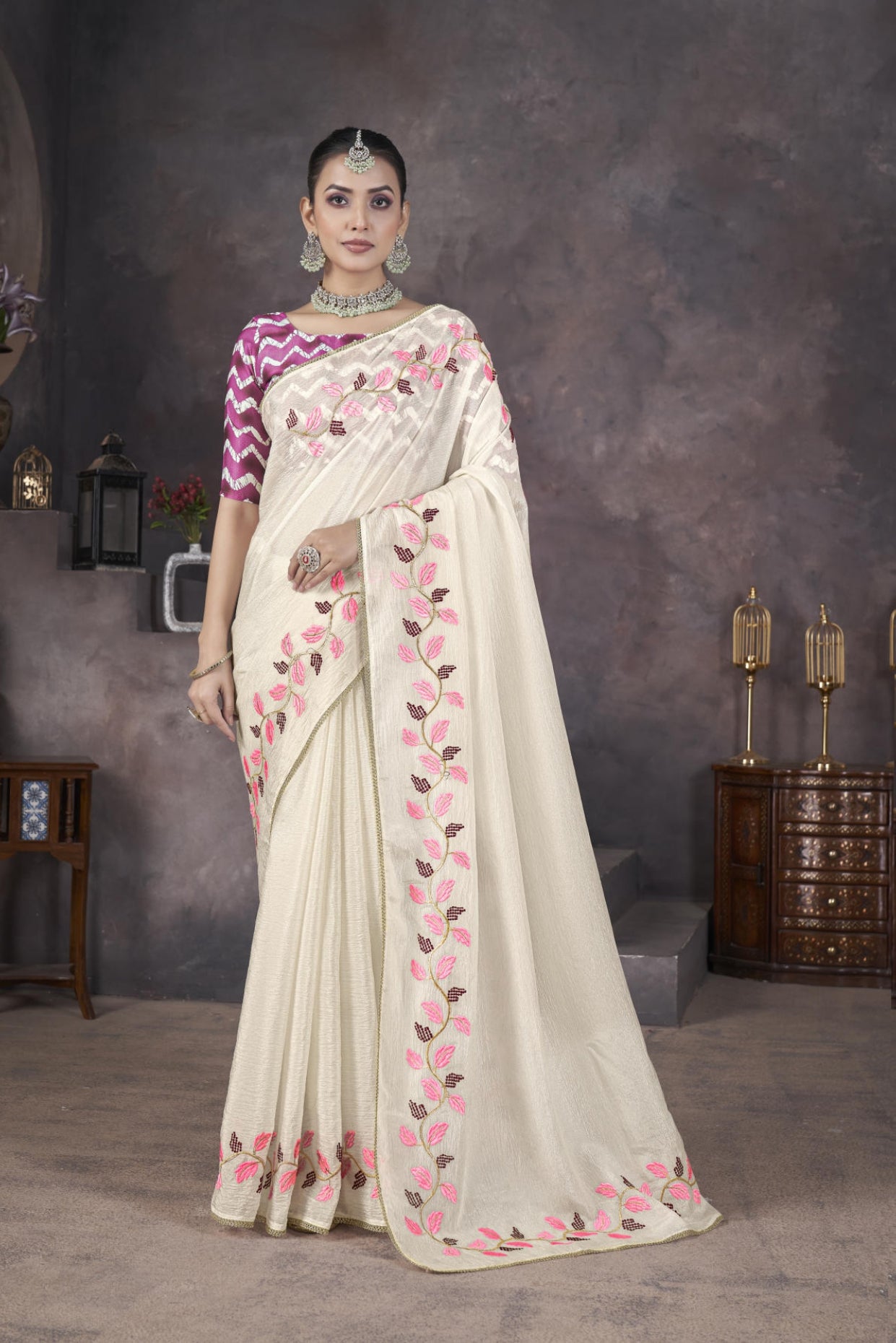 Model wearing Cream soft crush georgette saree with blue leaf thread embroidery and chevron batik blouse