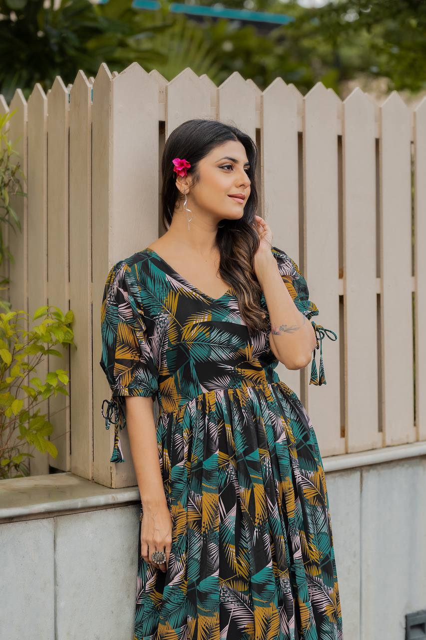 Woman wearing a black Georgette gown with a vibrant yellow, green, and pink tropical leaf print, a V-neck, and flared skirt outdoors.