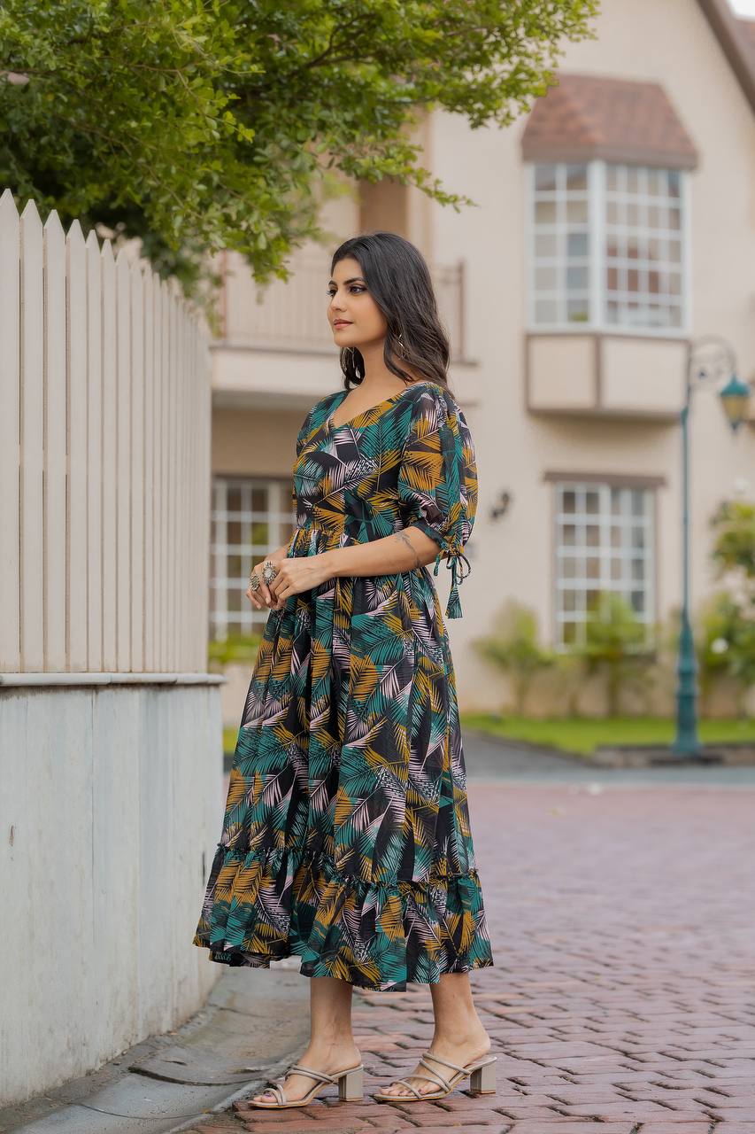 Woman wearing a black Georgette gown with a vibrant yellow, green, and pink tropical leaf print, a V-neck, and flared skirt outdoors.