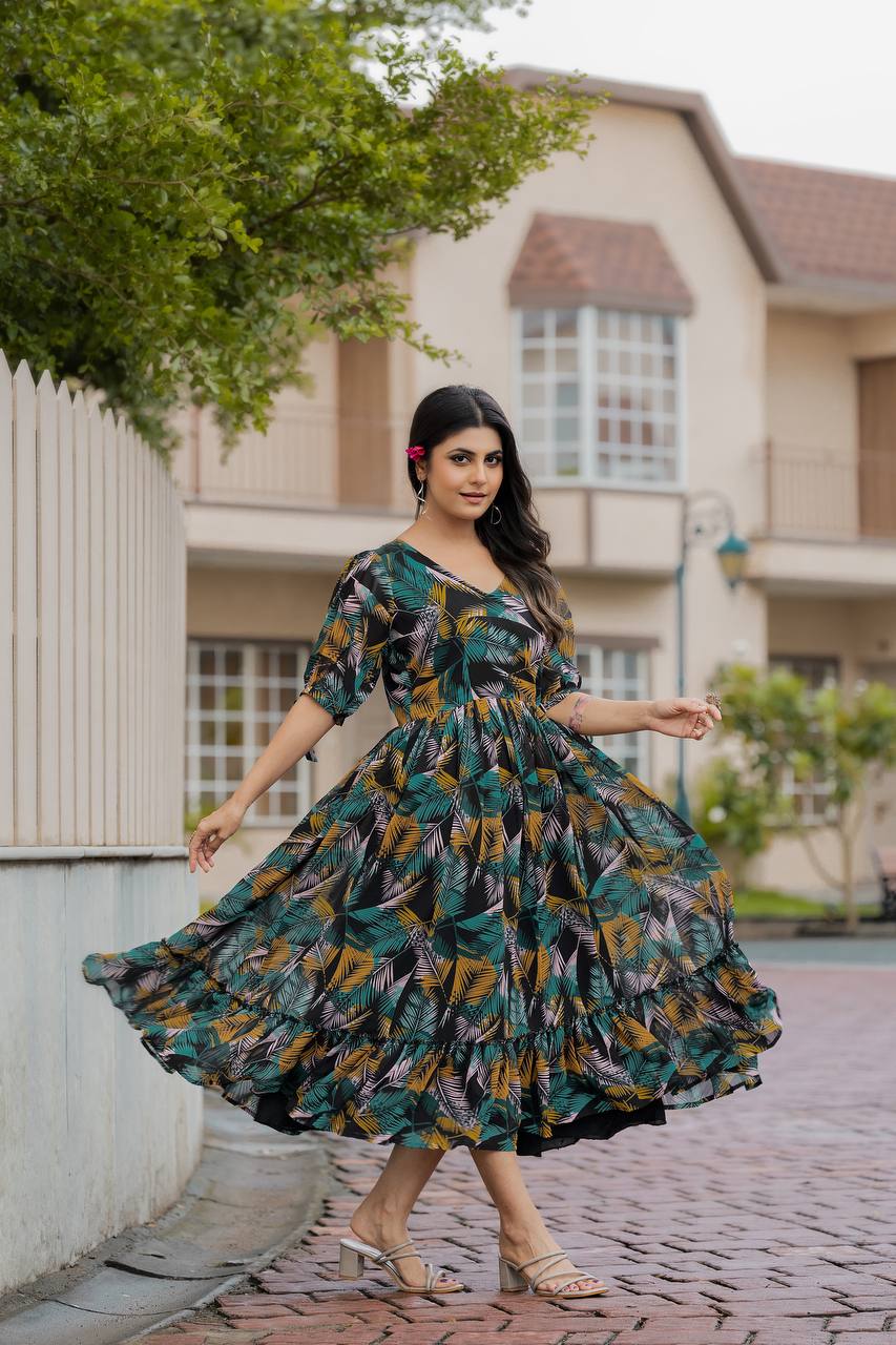 Woman wearing a black Georgette gown with a vibrant yellow, green, and pink tropical leaf print, a V-neck, and flared skirt outdoors.