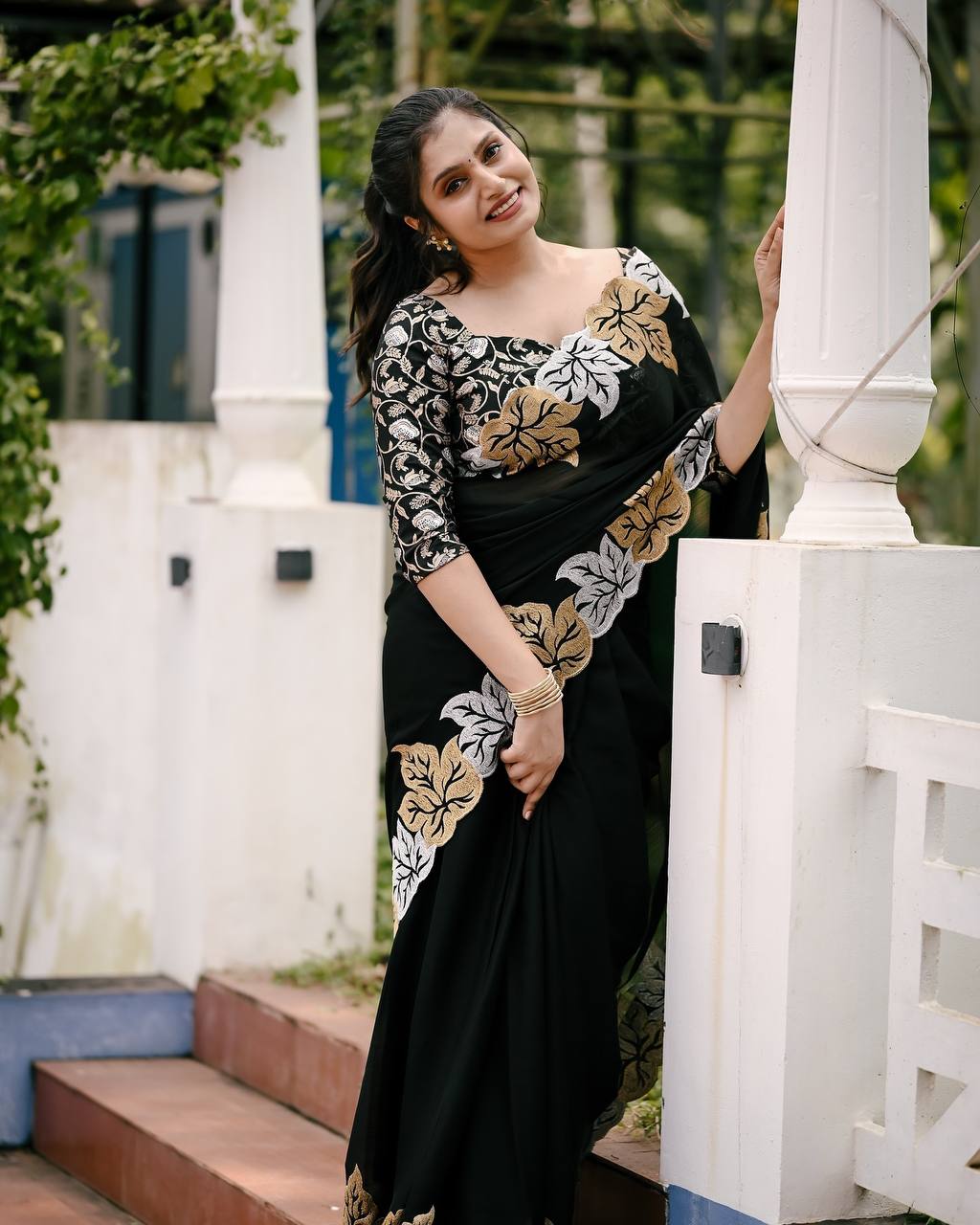 Woman wearing satin chiffon silk saree with large leaf jari embroidery and cutwork border