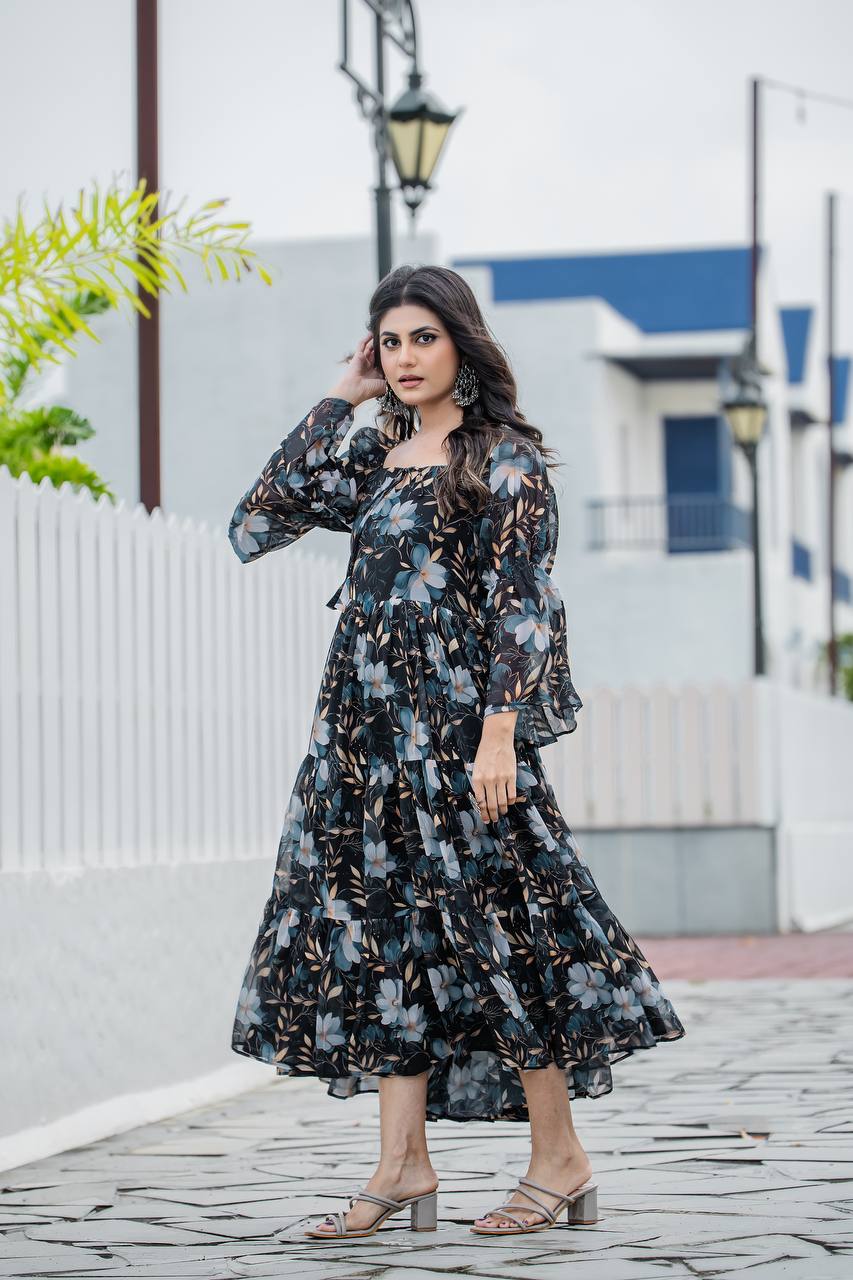 Model wearing black floral print georgette gown with tiered skirt and bell sleeves spinning outdoors