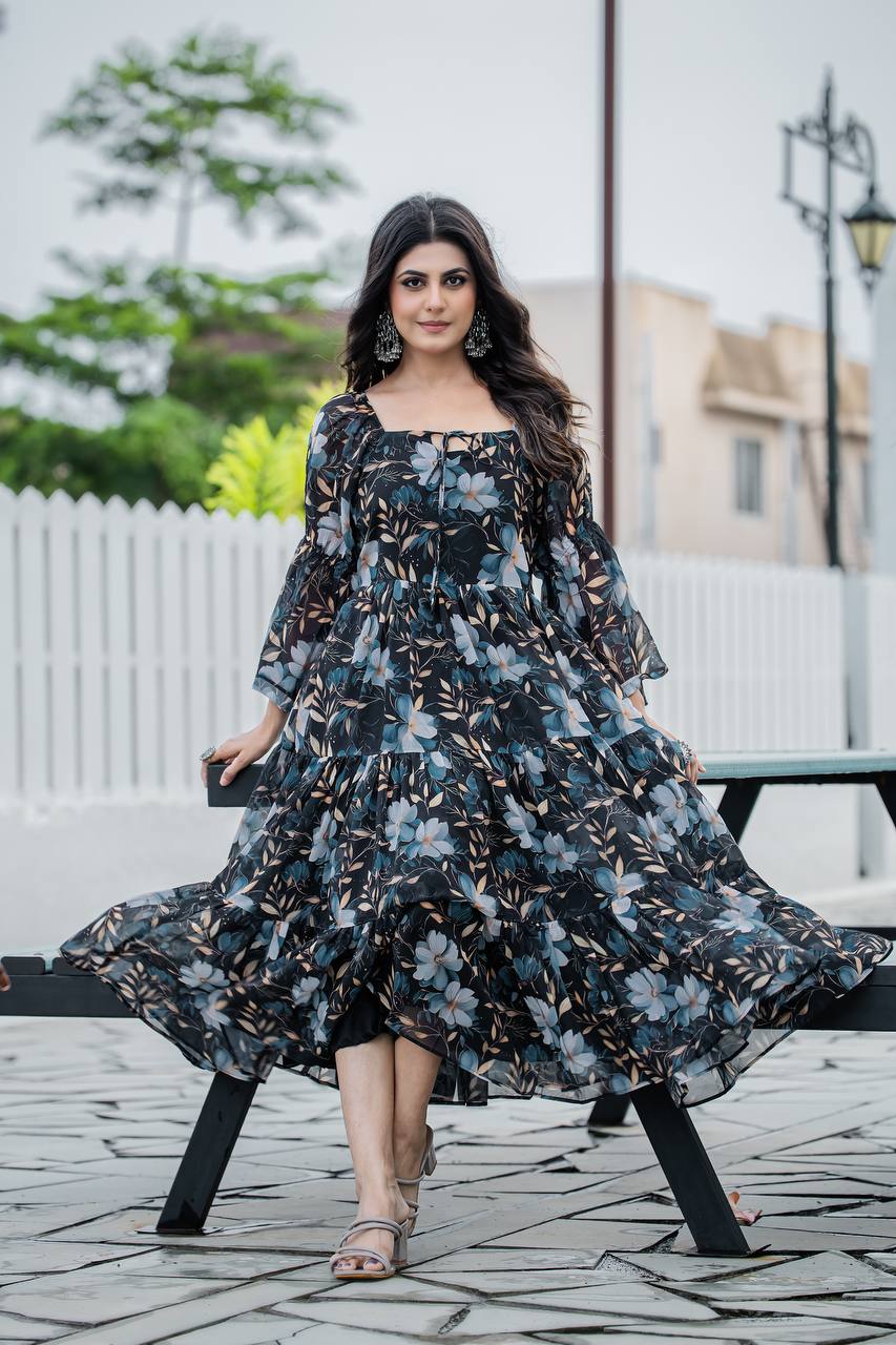 Model wearing black floral print georgette gown with tiered skirt and bell sleeves spinning outdoors