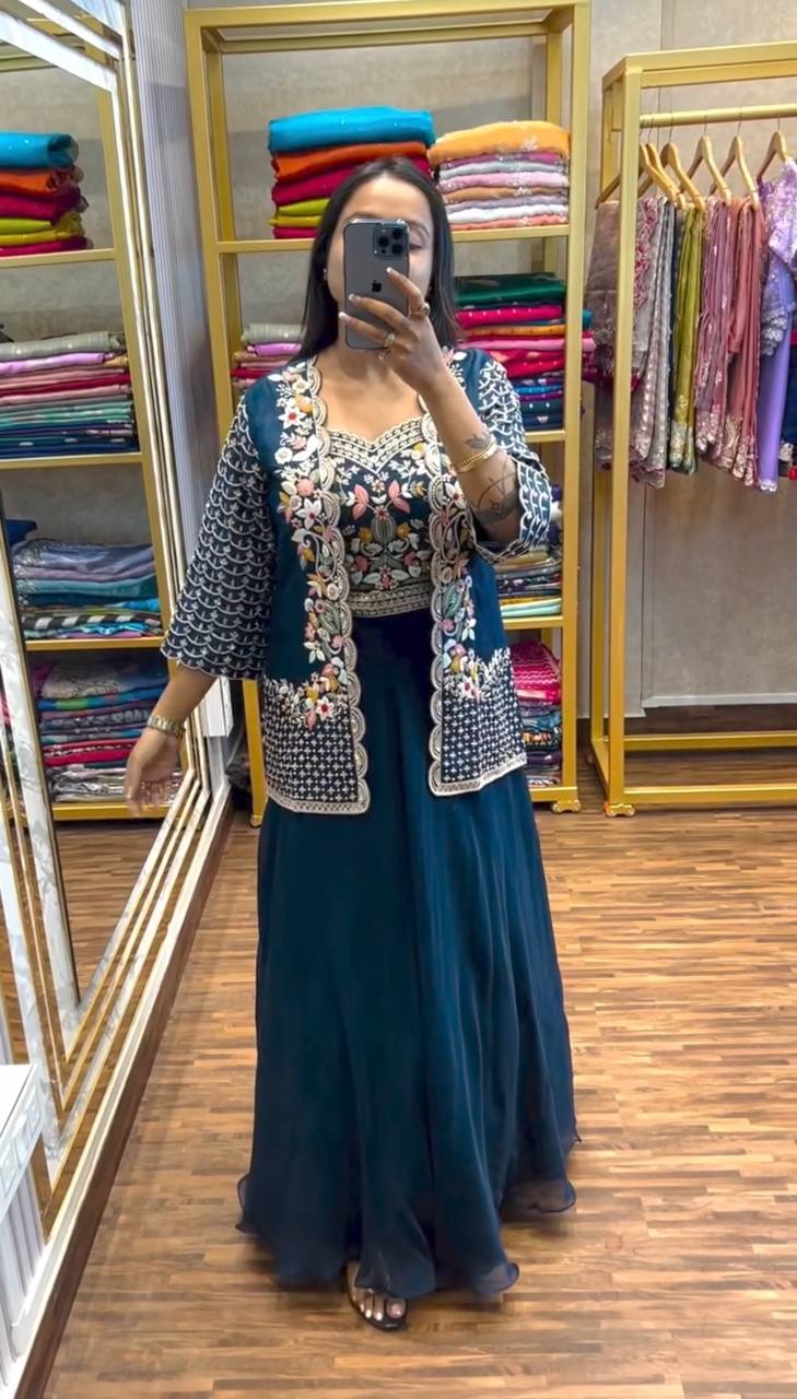 Woman wearing teal jacket lehenga set with floral sequin embroidery and scalloped edges looking in mirror
